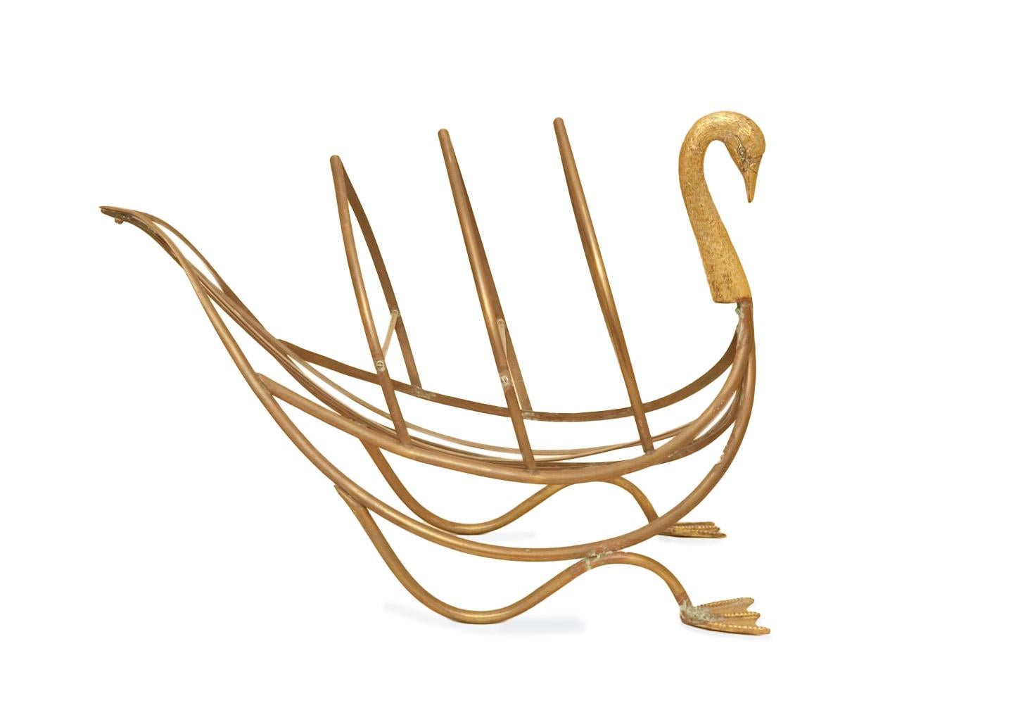 A magazine/newspaper rack in the form of a patinated brass swan with webbed feet and detailed brass neck and head. Stamped 