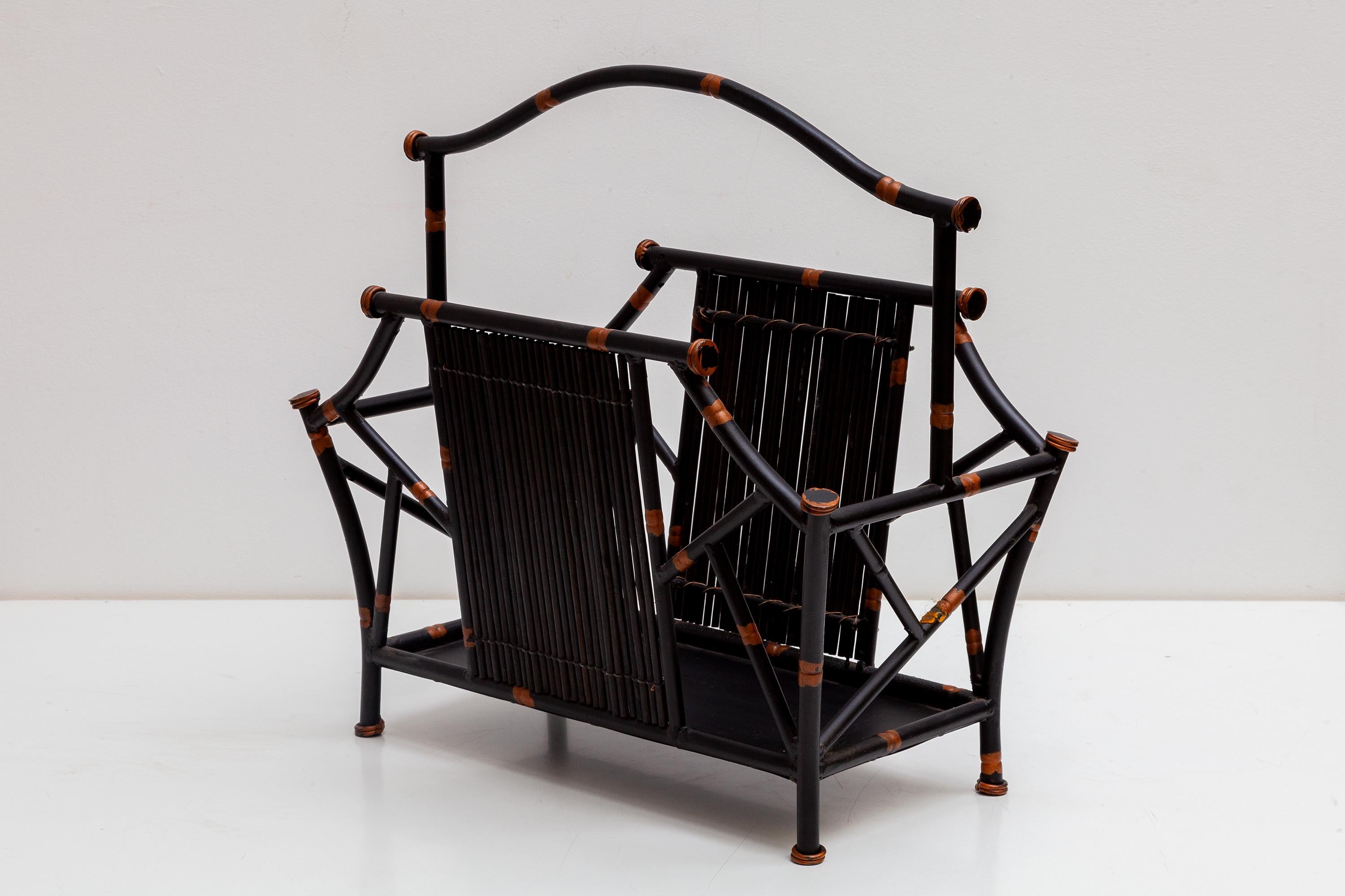 Metal magazine rack black iron faux bamboo, France 1970s vintage. Magazine rack in the manner of Maison Baguès. Hollywood Regency style crafted to look like naturel bamboo painted in black with gold accents. In perfect condition.The Mid-century