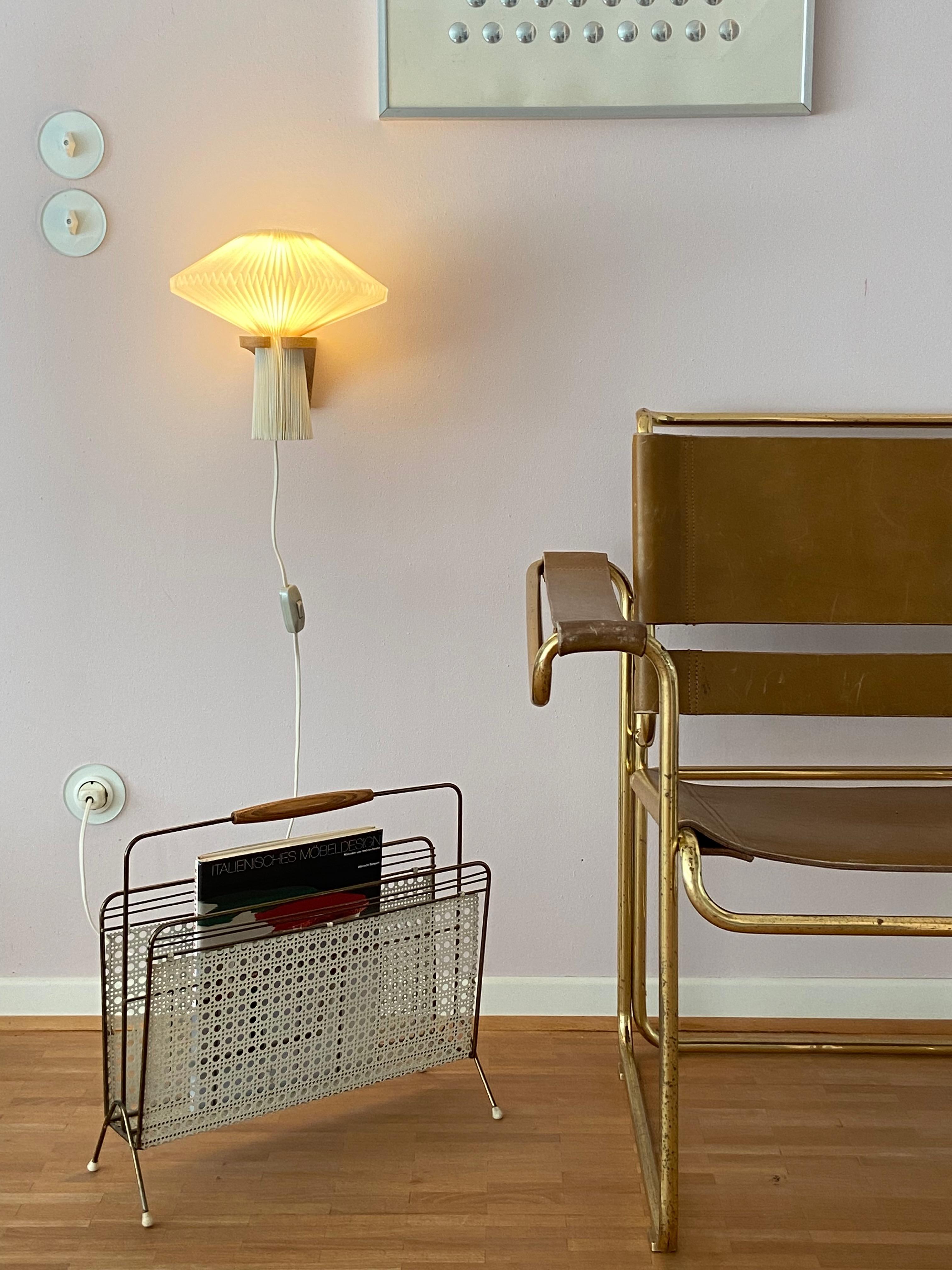 Beautiful magazine rack from the 1950s made in Austria. Design attributed to Mathieu Matégot. White coloured mesh sheet, brass and wood handle. The rack is in a very good condition.