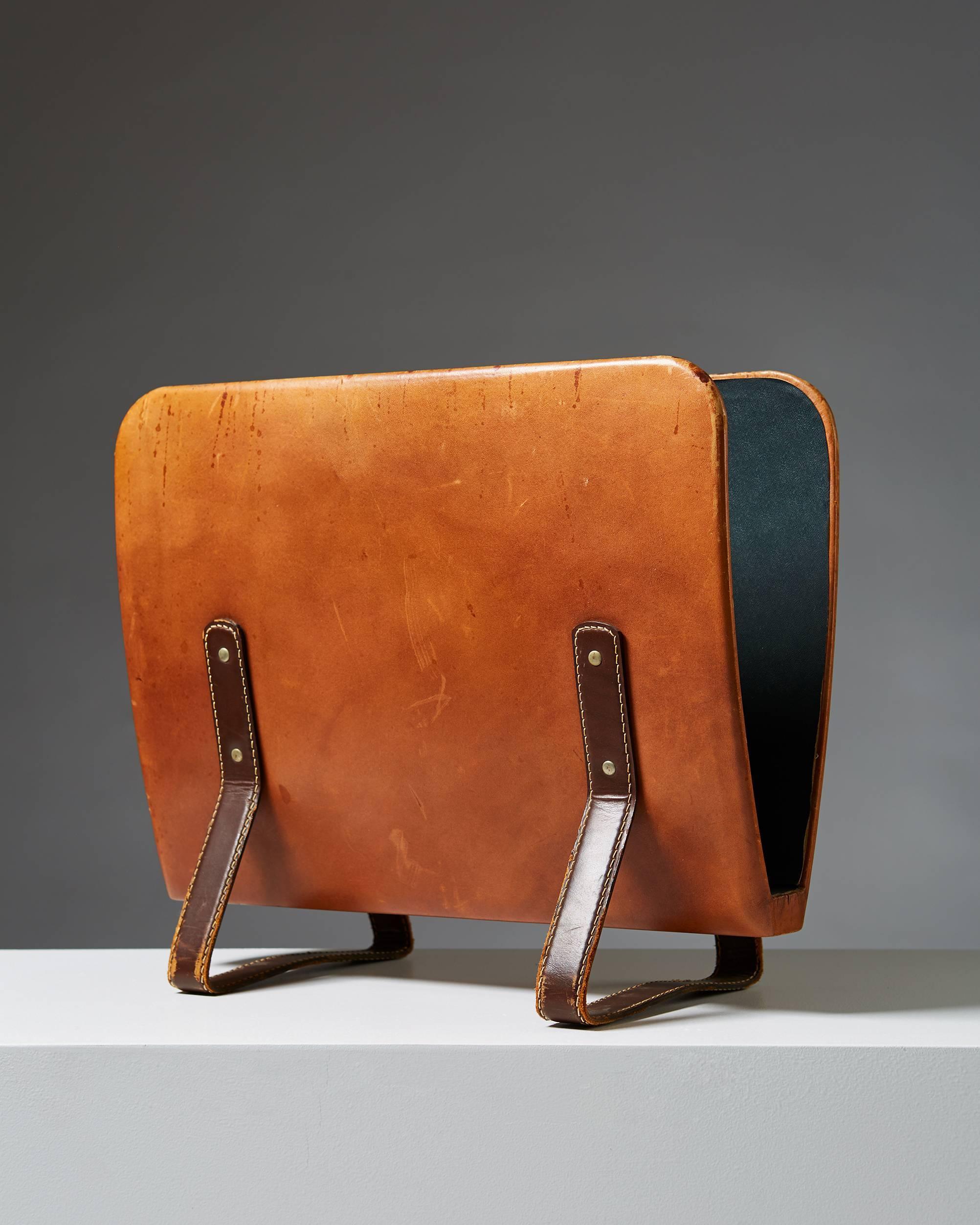 Magazine stand, anonymous, 
England, 1950s. 
Leather covered brass.

Measure: L 40 cm/ 15 3/4''
 W 15 cm/ 6''
 H 35 cm/ 13 3/4''.