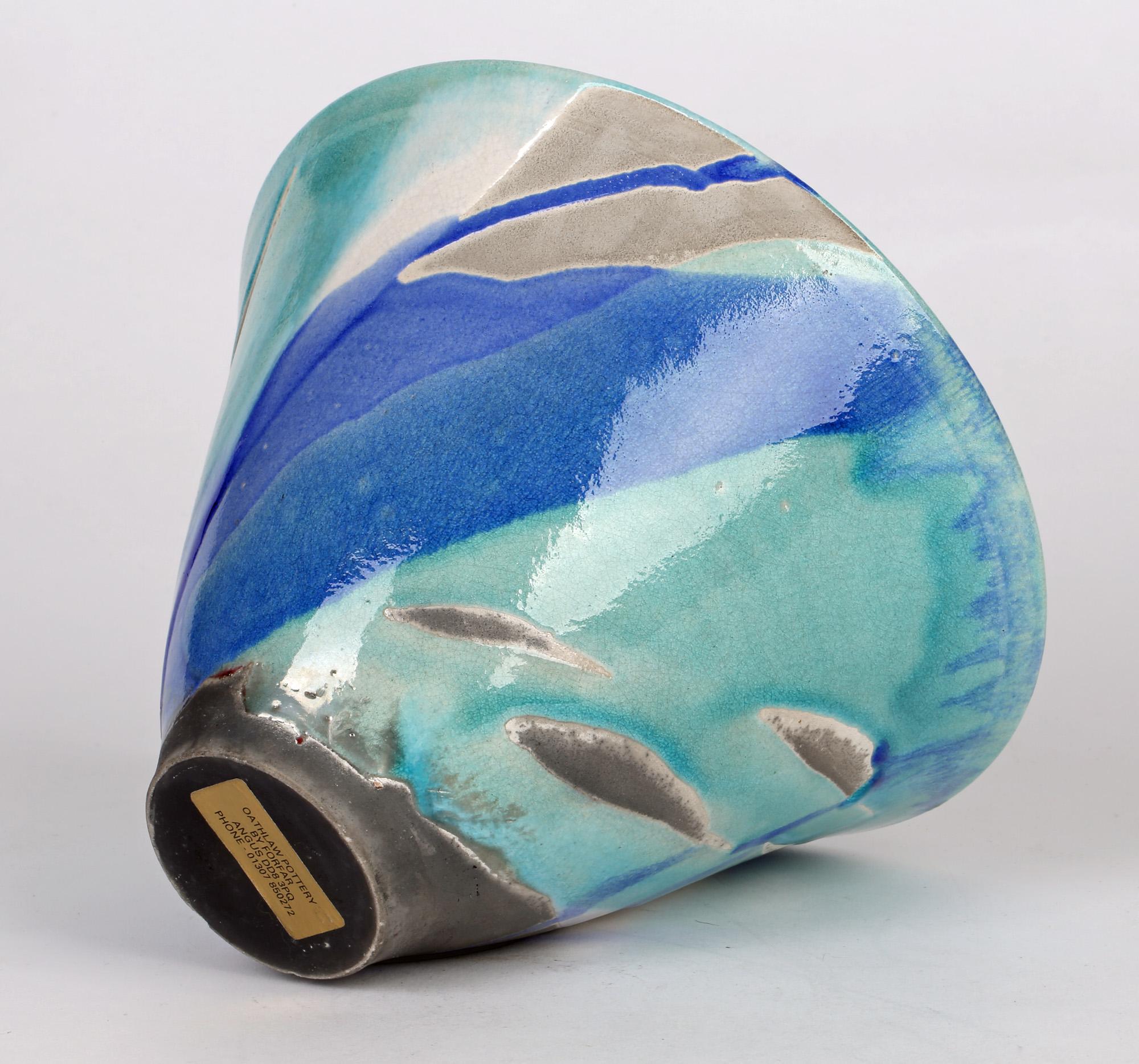 A striking Scottish studio pottery raku glazed bowl with turquoise and blue glazes by Maggie Kinnear. This bowl originates from the Oathlaw Pottery which started in 1988 and we believe it is an early example. Of conical shape the bowl stands on a