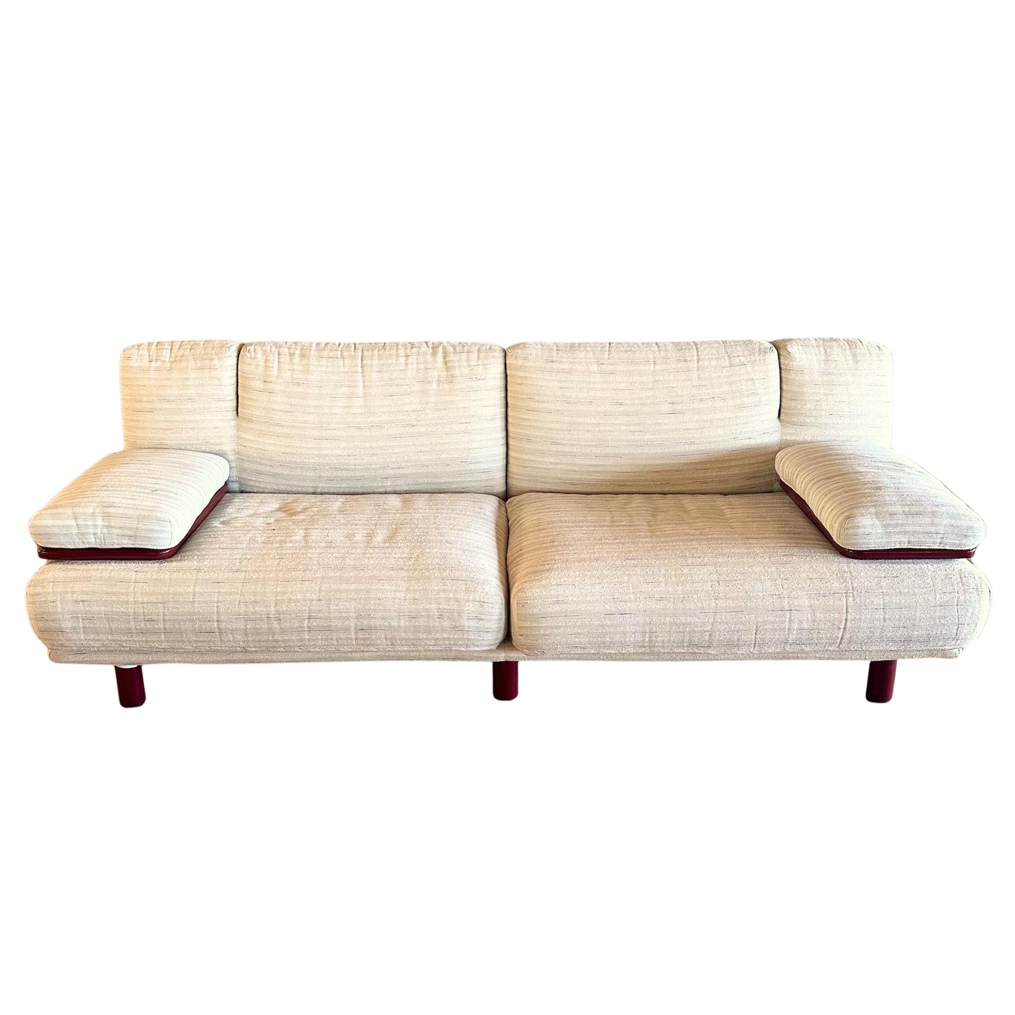 A standout of 1980s Italian design, the ‘Magia’ sofa by Bacci and Mazzoni for Giovanetti pairs playful forms with sharp detailing. The plush upholstery wraps around two sculptural seat sections with curved edges and matching lumbar cushions. Movable