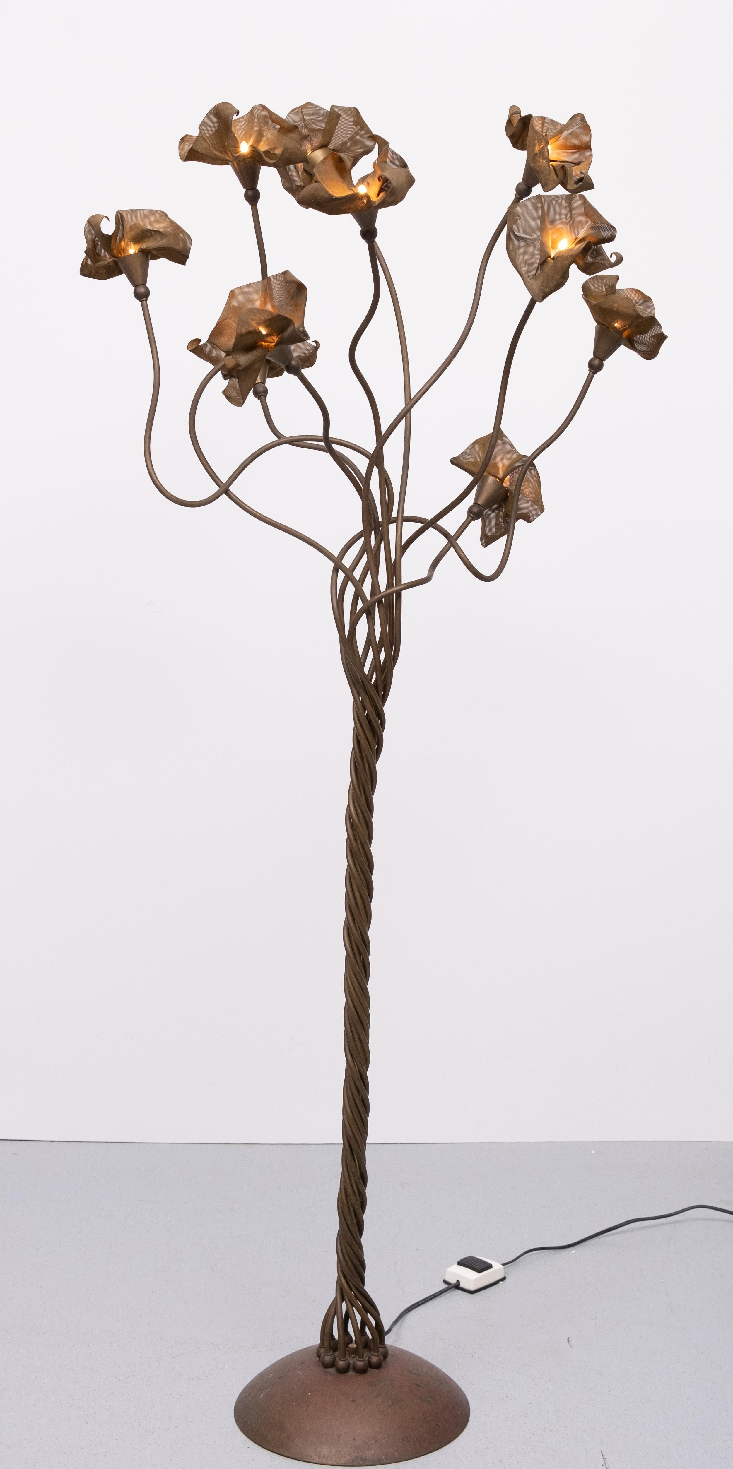 Lámpara de pie de bronce forjado en forma de árbol, con ramas de árbol de latón y 10 flores de latón auténtico perforadas.  Esta lámpara se inspira en la naturaleza y, cuando está encendida, atrae todas las miradas, pero al mismo tiempo es un