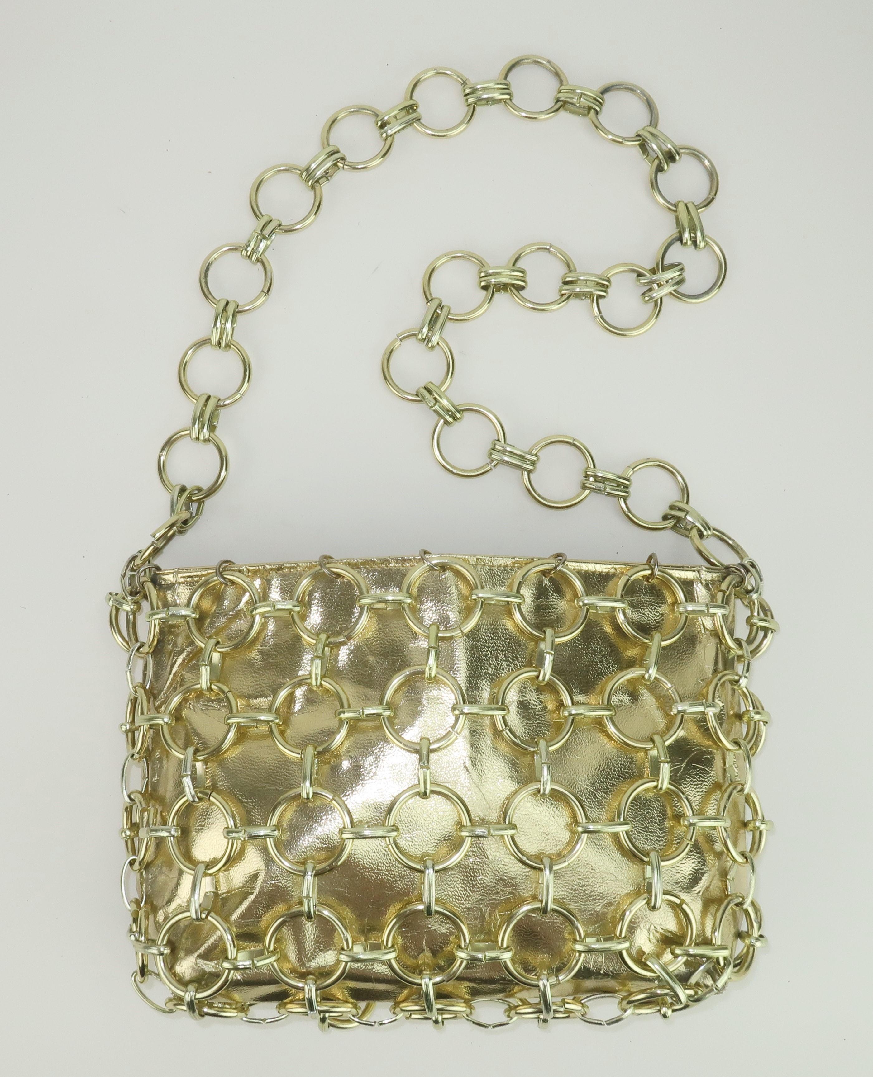 Get the Midas touch with the 1960's swinging style of a Magid gold chain link handbag.  The body of the handbag is a gold vinyl, with a leather look, completely caged with rings.  The interior offers two generous open pockets and a center zippered
