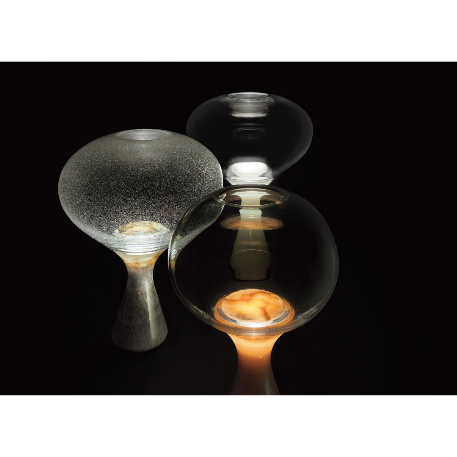 Magika Medium Lamp by Kreoo 
Designed by Enzo Berti
Dimensions: Ø 36 x H 52 cm.
Base: Ø 12 cm.
Materials: Ambra Onyx and transparent glass.

Available in different marble, onyx, and glass options. Available in three different sizes. There are two