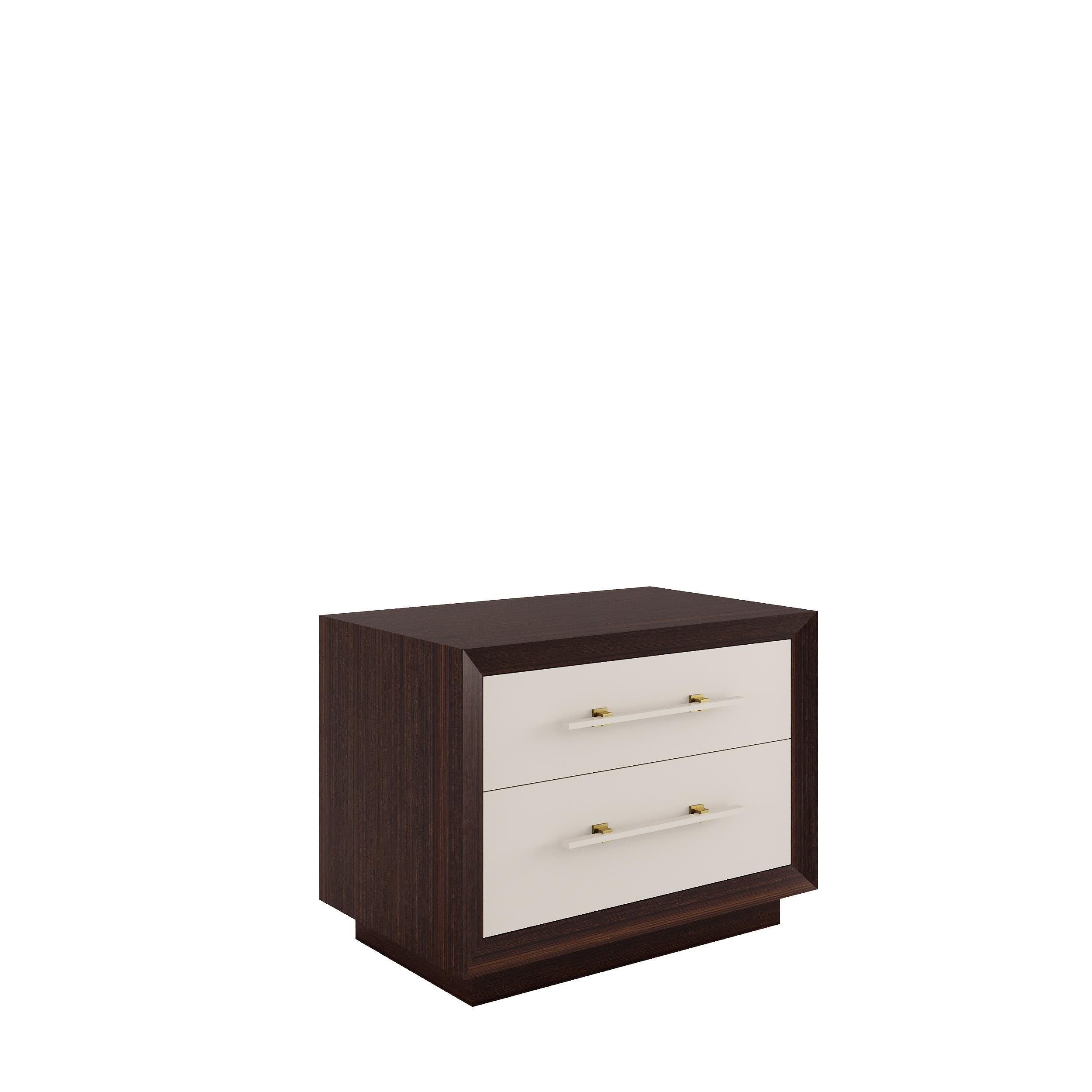 MAGNA is a robust and elegant nightstand, made of veneered wood with two lacquered drawers and embellished with brass details.‎ 

Finished in lacquer or veneered wood or simply combining both.

Primary image: shown in glossy Eucalyptus Fumé