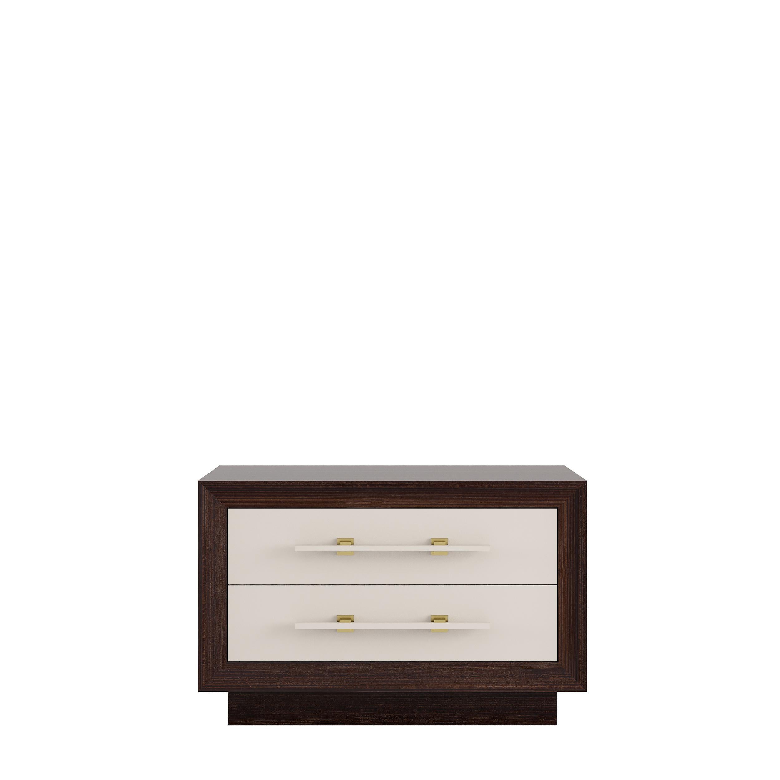 MAGNA is a robust and elegant nightstand, made of veneered wood with two lacquered drawers and embellished with brass details.‎ 

Finished in lacquer or veneered wood or simply combining both.

Primary image: shown in matte lacquered structure in