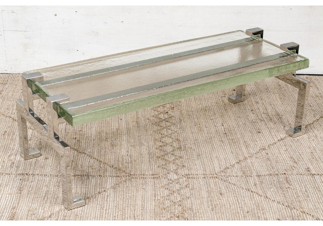 La table basse Jewell, qui fait partie de la Collection S, a été fabriquée avec soin à partir d'acier inoxydable poli à la main et d'un épais plateau en verre moulé à la main avec des côtés en galets. Gravure à l'acide du logo 