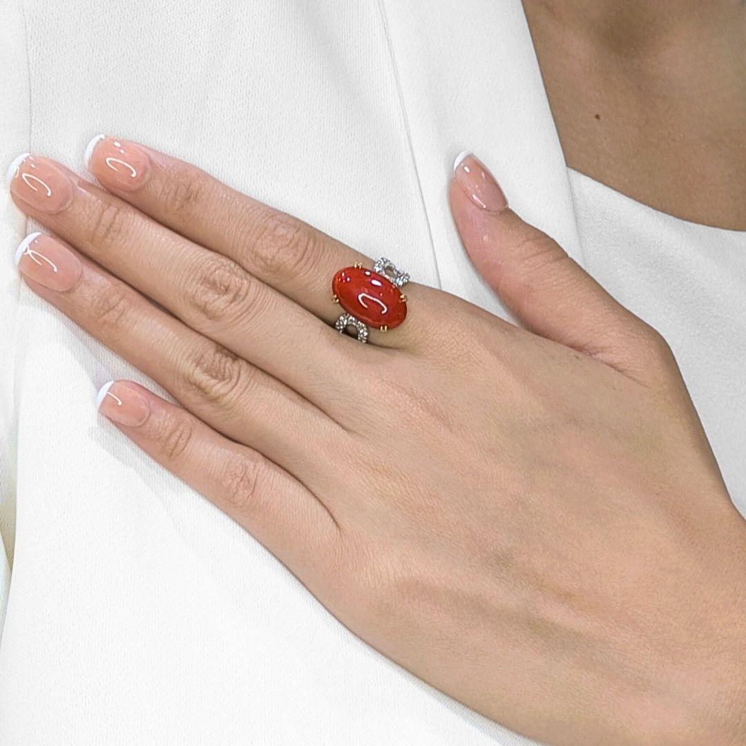 Dieser neue, ungetragene Ring aus zweifarbigem 18-karätigem Gold ist eine auffallende Verschmelzung von Wärme und Brillanz. In seinem Zentrum sitzt eine rote Koralle im Ovalschliff, die natürlichen Charme und Tiefe ausstrahlt. Um sie herum schimmern