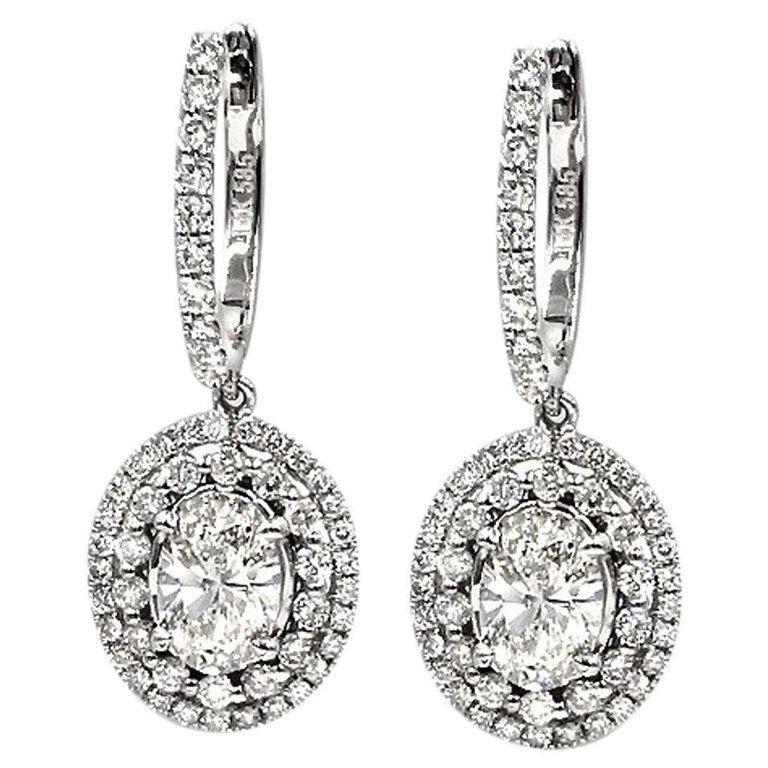 Ladies Beautiful diamond drop earrings.
Handcrafted in 14k white gold.
Center contains 2 oval shaped diamonds total of 1.42 carat VS2 clarity   I color.
Sides contain 0.94ct round brilliant cut diamonds.
The dazzling diamonds are handset in prong