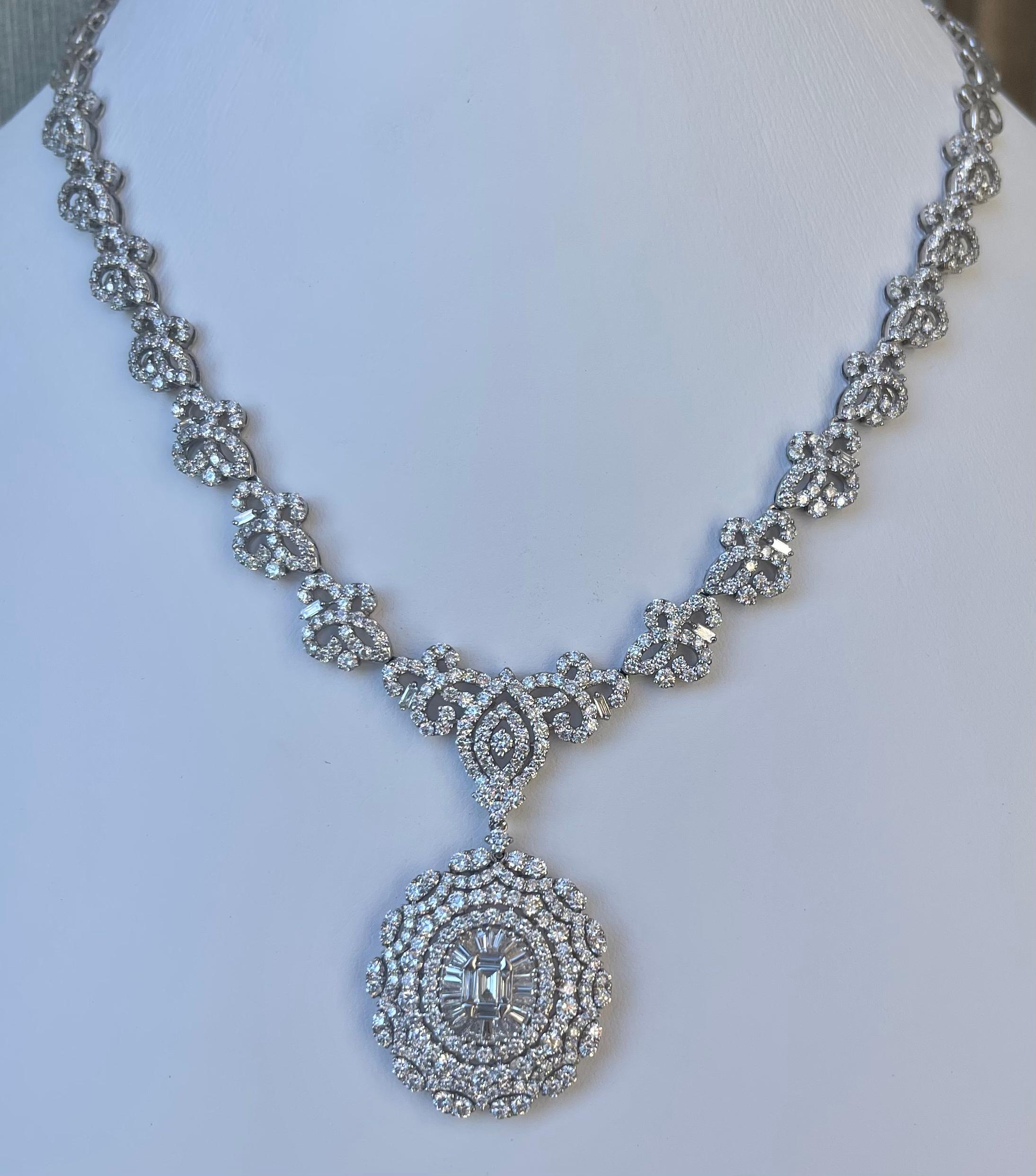 
Magnificent ladies 18 karat white gold diamond medallion pendant necklace.   The oval shaped diamond medallion pendant hangs from a connected 16” long diamond chain with a fancy repetitive pattern that is encrusted in diamonds halfway up the
