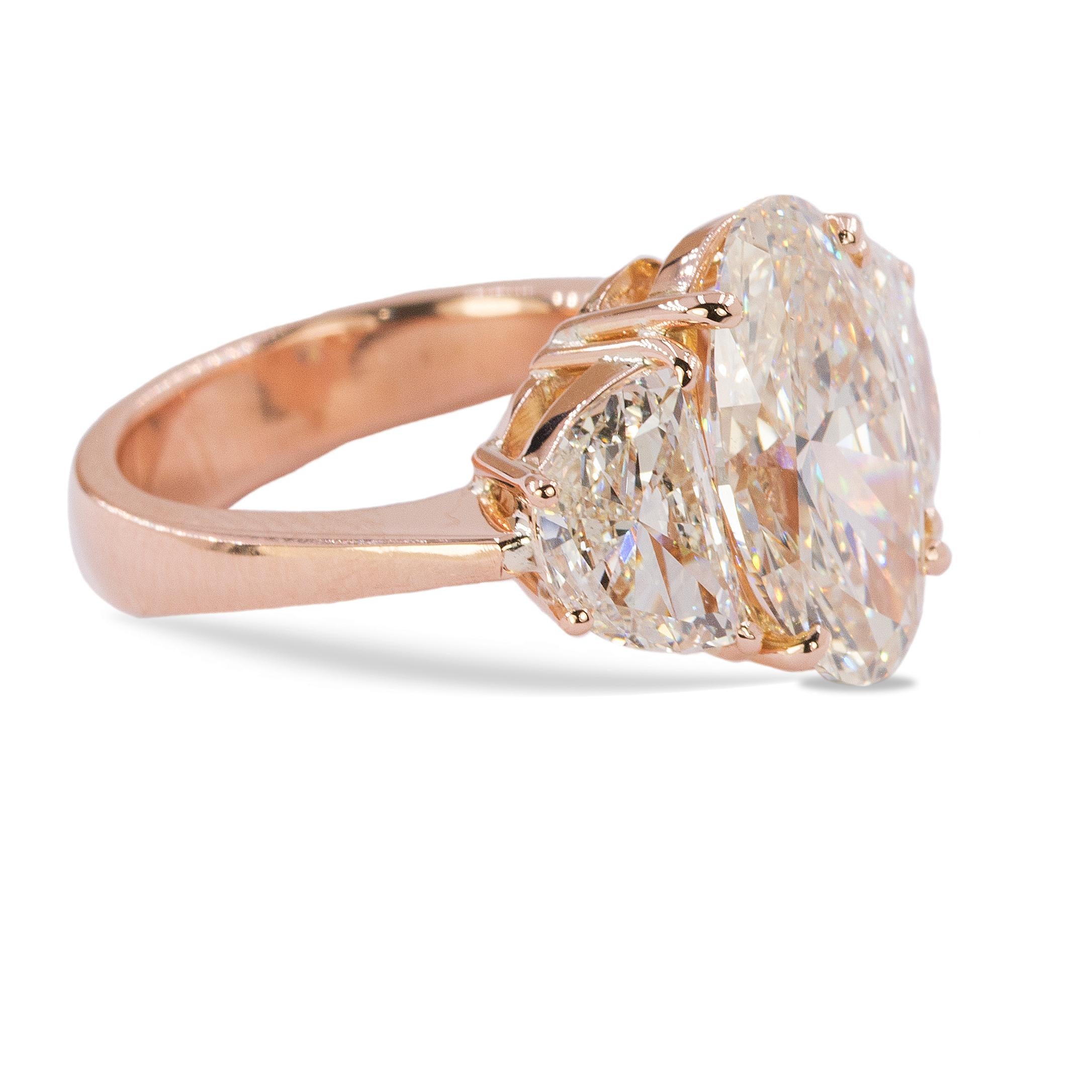 18k Rose gold ring with GIA certified 4.72 carat, K color, VS2 clarity oval brilliant diamond and 2 J color VS1-SI1 clarity half moon cut diamonds weighing 2.01 carats.