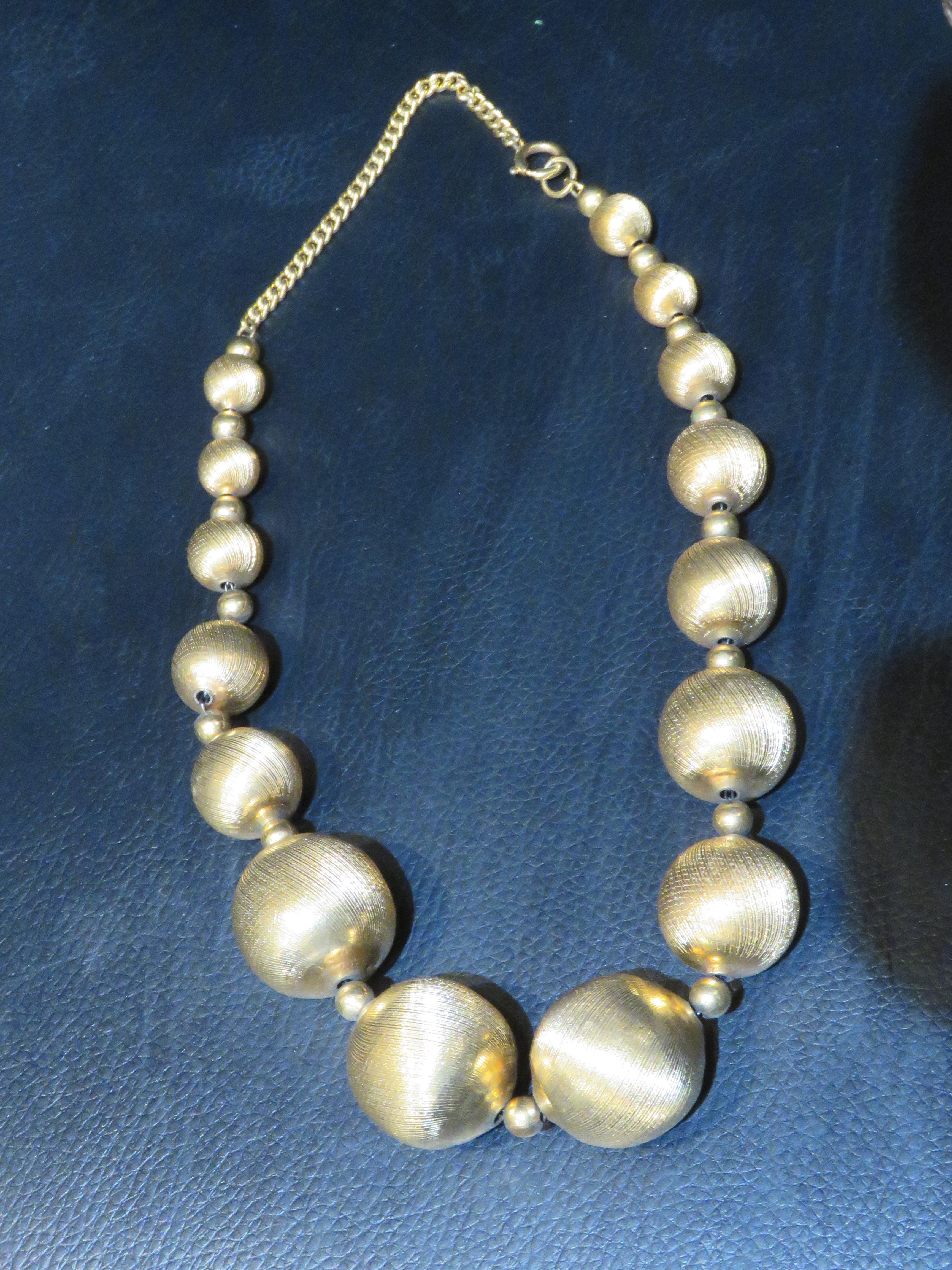El siguiente artículo que ofrecemos es un Importante e Insólito Collar de Bolas Graduadas de Oro Recubierto de 18 KT Esta Preciosa Pieza es de Época y tiene 3 Magníficas Bolas Doradas Tejidas. Sacado de una importante finca neoyorquina de varios