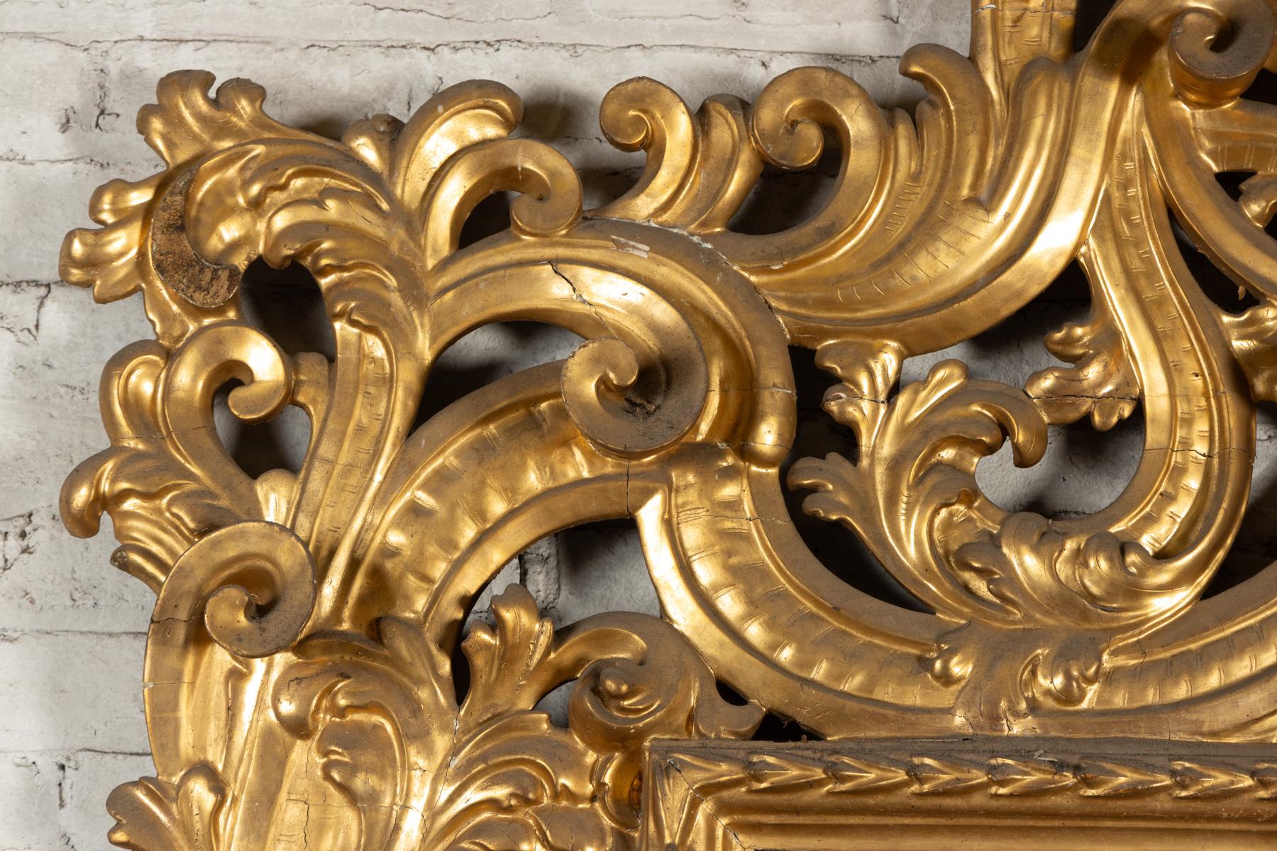 Magnifique miroir Florentine du 18ème siècle lourdement sculpté, grand miroir à la feuille d'or.  Le cadre est largement sculpté de feuilles d'acanthe, de décorations florales et de rinceaux, de la lourde période rococo.  Le miroir est doté de sa