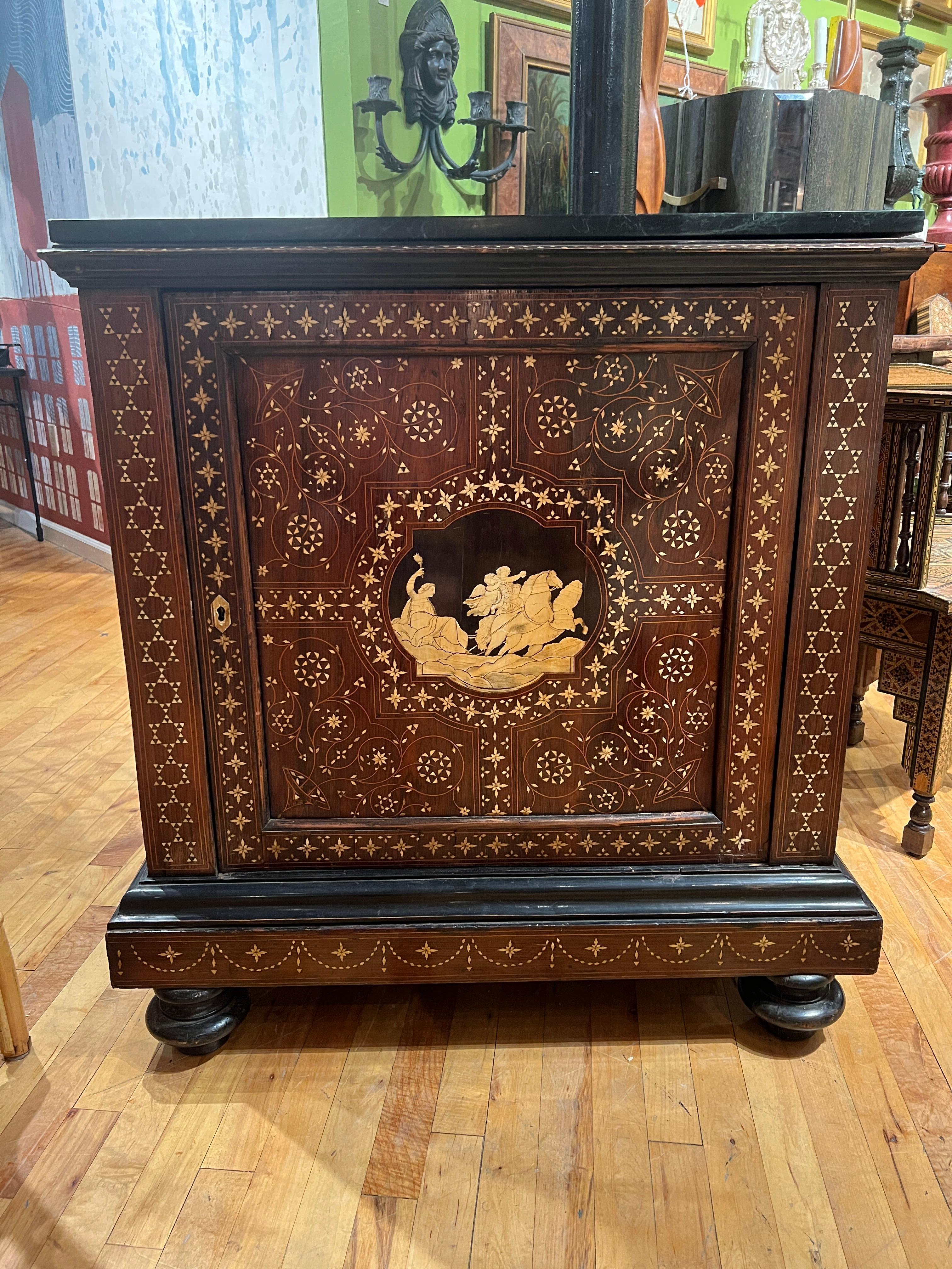 Italiano, circa 1900.

Un fantastico mobile impiallacciato in palissandro e legno duro ebanizzato. Forma rettangolare con piano in marmo verde scuro più tardi, modanatura superiore applicata sopra un'anta del mobile a un solo pannello incernierato