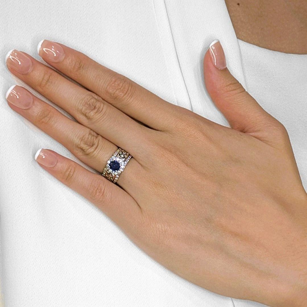 Cette bague intemporelle met en valeur un saphir bleu foncé ovale de 0,50ct, rayonnant d'élégance et de sophistication en son centre. Entourant le saphir, 52 diamants ronds naturels de taille brillant (0,50ct au total, couleur H, pureté VS) forment