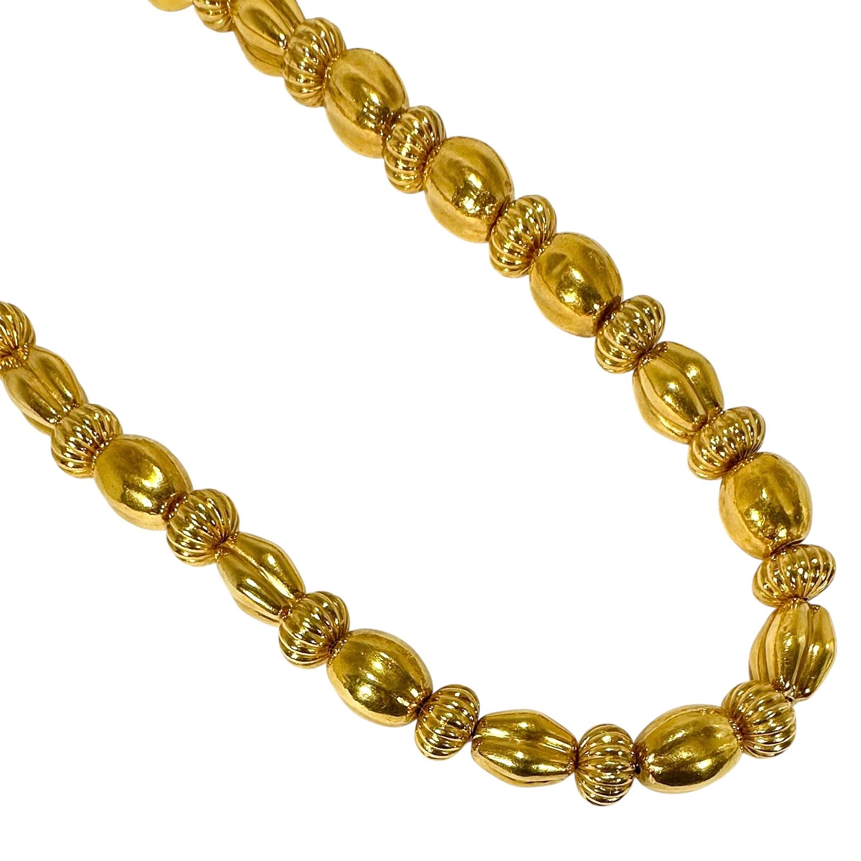 Questa magnifica collana vintage in oro giallo 22K lunga trent'anni è un tesoro iconico di Lalaounis. L'alternanza di tondi scanalati con maglie ovali a soffio pizzicate e martellate crea un'offerta visiva entusiasmante. L'aspetto complessivo è