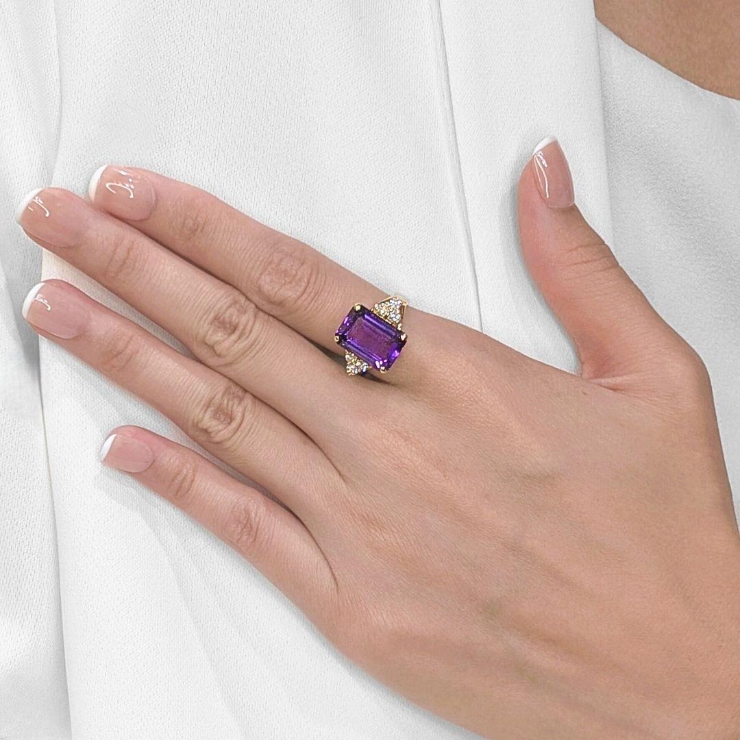 Attira l'attenzione con questo splendido anello da cocktail, caratterizzato da una lussuosa ametista dal taglio smeraldo di 6,68 carati che irradia un viola ricco e regale da ogni angolazione. Affiancato da sei diamanti tondi brillanti naturali