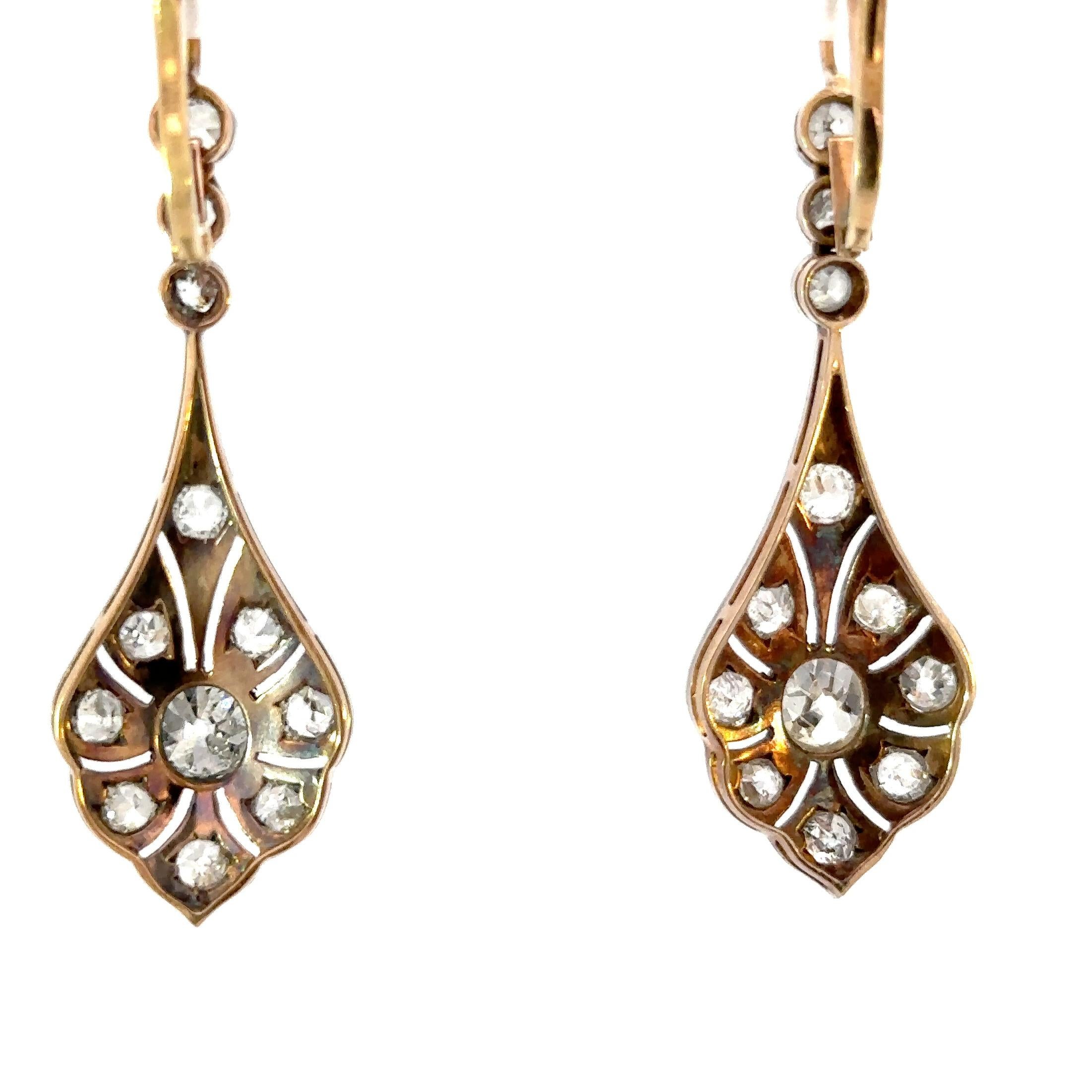 This extraordinary pair of antique earrings, dating to around 1900, is a rare survival of regal beauty. Crafted in a luxurious combination of 18k gold and silver, they shimmer with approximately 5.50 carats of old-cut diamonds, each one alive with