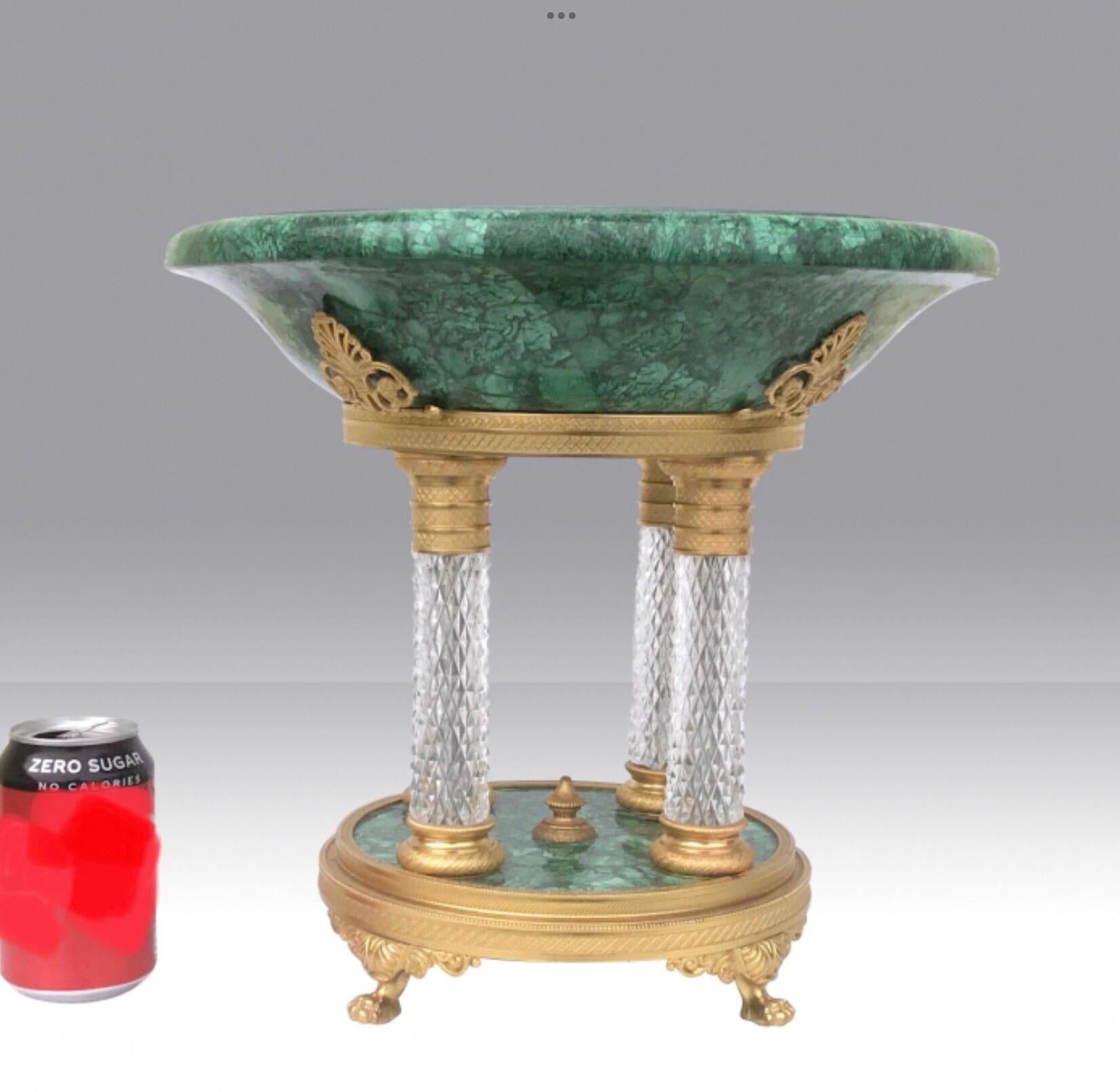 Magnificent French Malachite Tazza.
The malachite tazza is accented by four Fleur De Lit motifs composed of gilted bronze dore centered above each cut crystal pillar.
The French crystal columns are completed by a malachite base supported by four