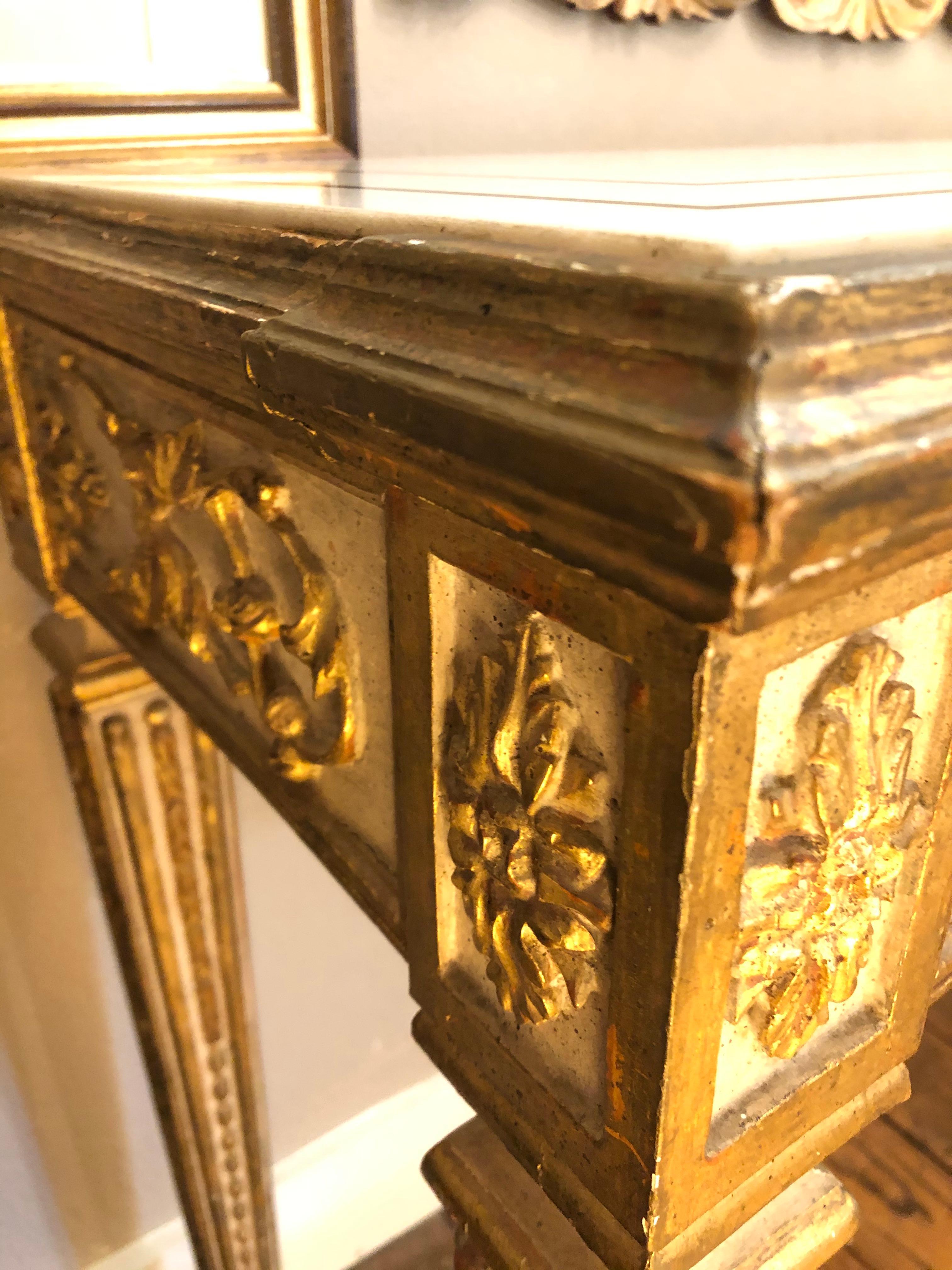 A spectacular 19th century antique Italian console having carved wood painted and gilded base in a wonderful cream and gold, with a piece de resistance white marble top with dark inlay border and central bow decoration. A show stopper in any room or