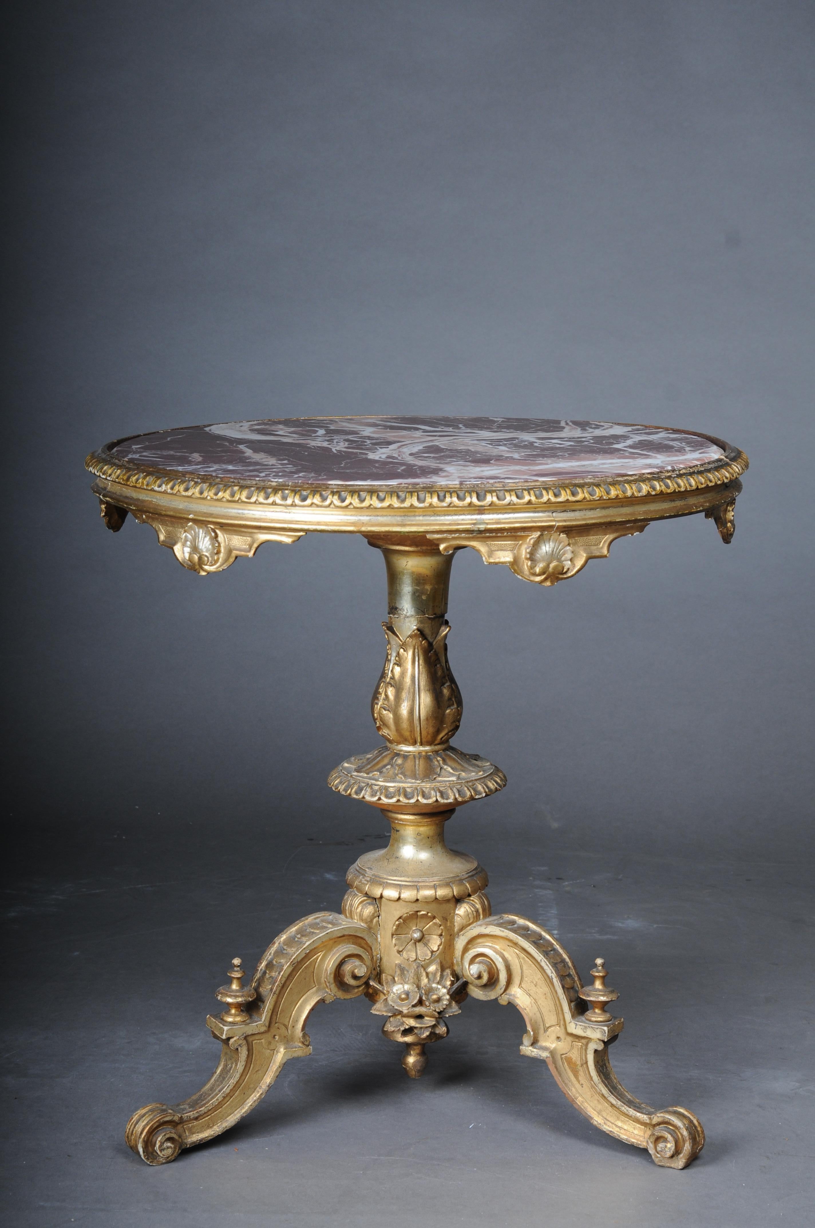 Magnificent antique side table gilded with marble top from around 1860

Richly carved solid wood body with rich ornaments, finely carved. Balustrade with leaf ornaments articulated on three curved and also richly carved legs. Very ornate and