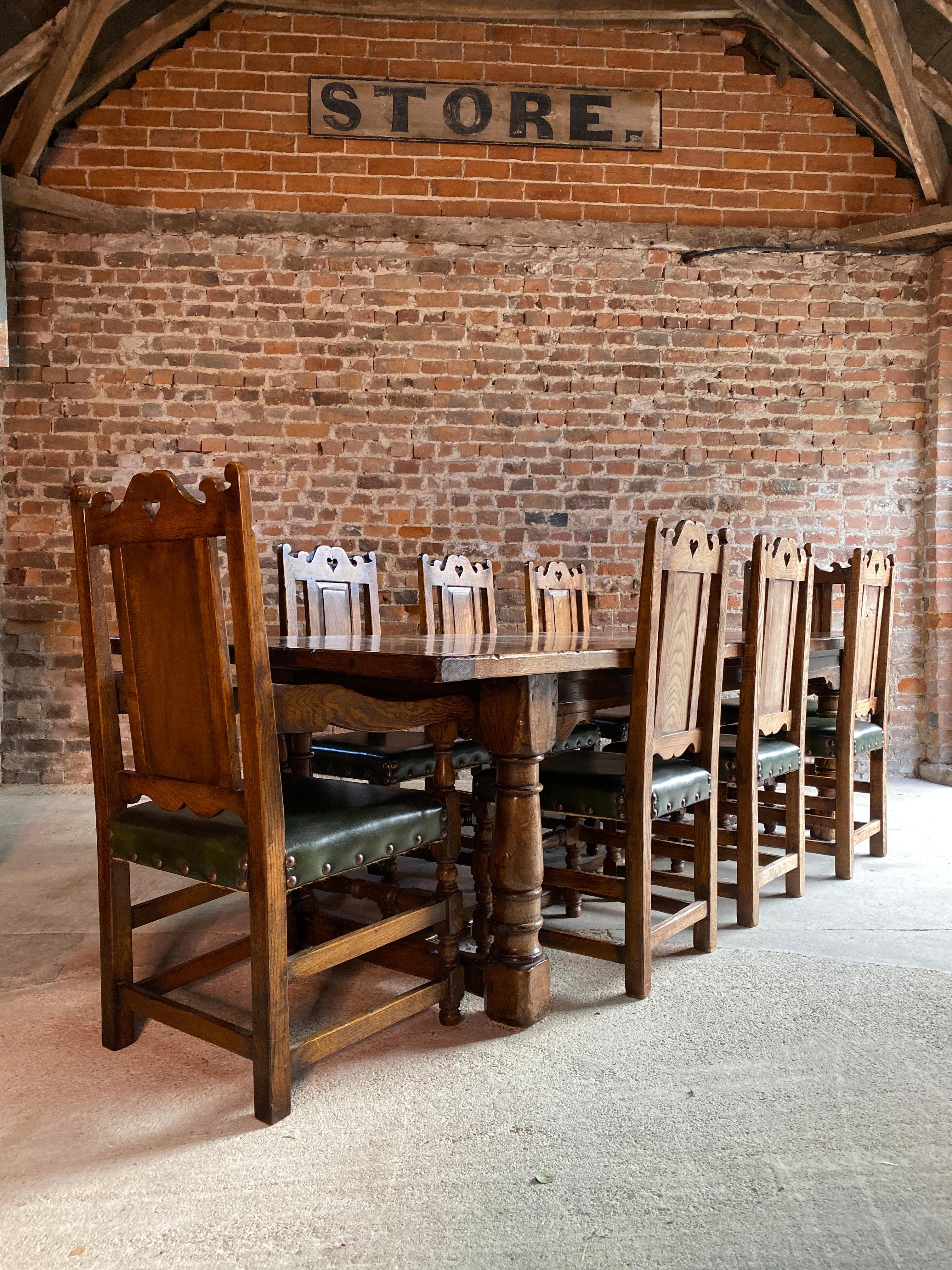 A stunning 20th century antique style solid oak refectory dining table with eight matching chairs, the rectangular plank top with cleated ends, raised on turned supports united by wide H-stretcher on bulbous turned legs, married with eight 17th