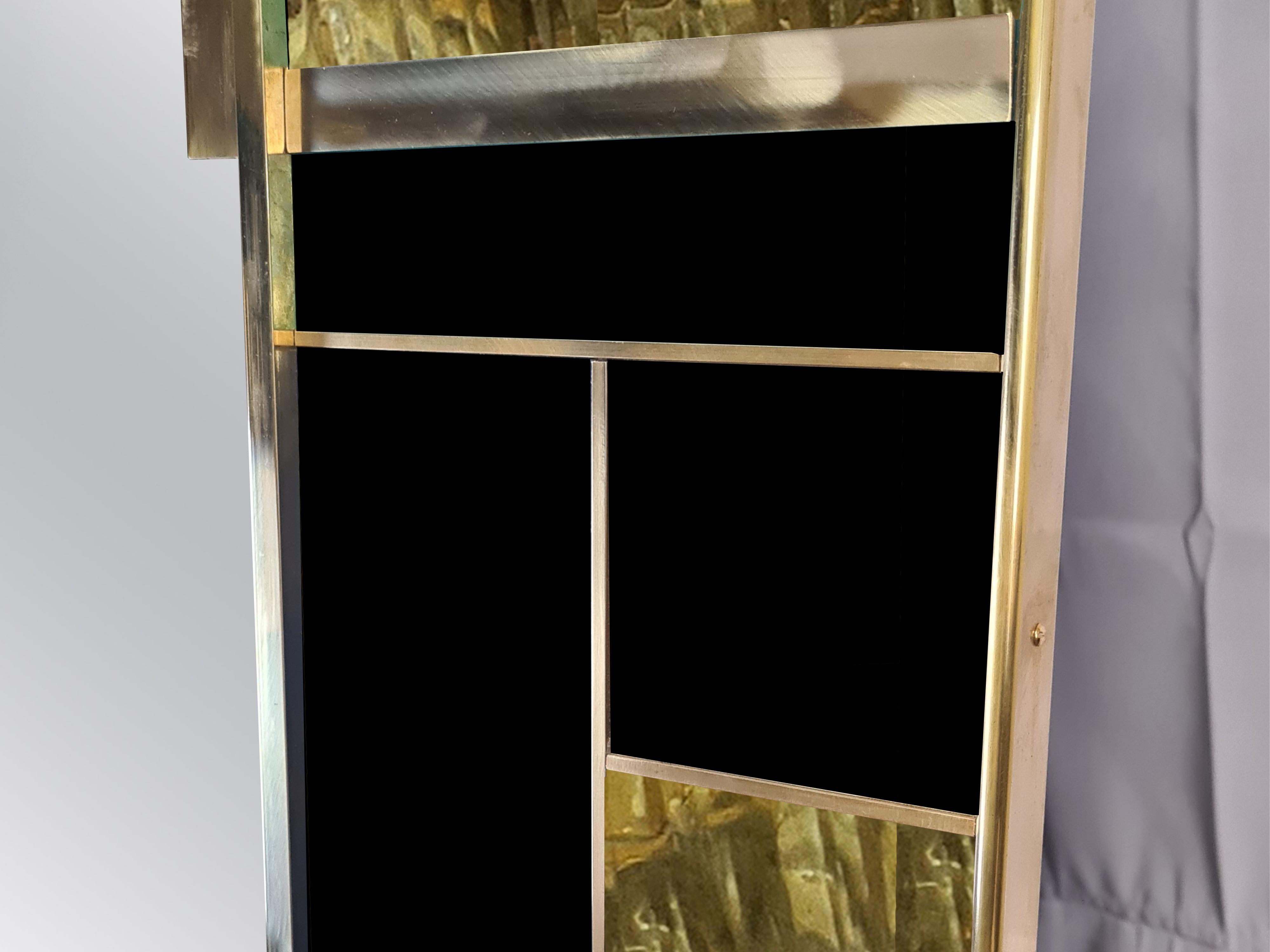 The Magnificent black Murano glass and brass wall mirror with square geometric trim is an extraordinary piece of modern design. 

Made in Italy, this mirror showcases the exquisite craftsmanship of Italian artisanship. It features a bold square