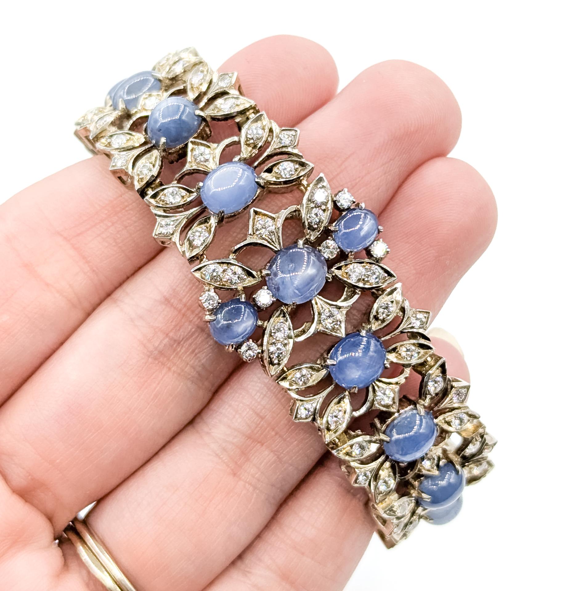 This exquisite bracelet is crafted in sterling silver and showcases a striking Brutalist design, adorned with 10.00 carats of cabochon-cut blue sapphires and 2.00 carats total weight of round brilliant diamonds. Each sapphire is nestled within an