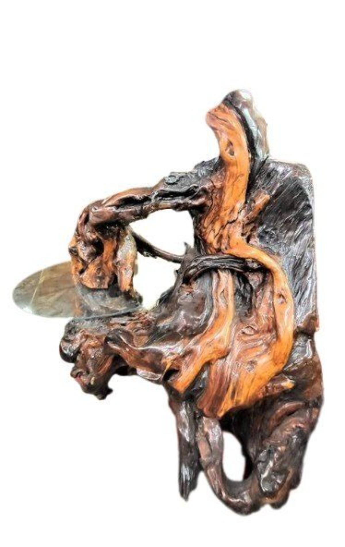 Magnifique sculpture en bois de ronce. L'artiste en a fait une table décorative en y incluant un morceau de verre rond. Pièce rustique intéressante pour votre maison ou votre entreprise.