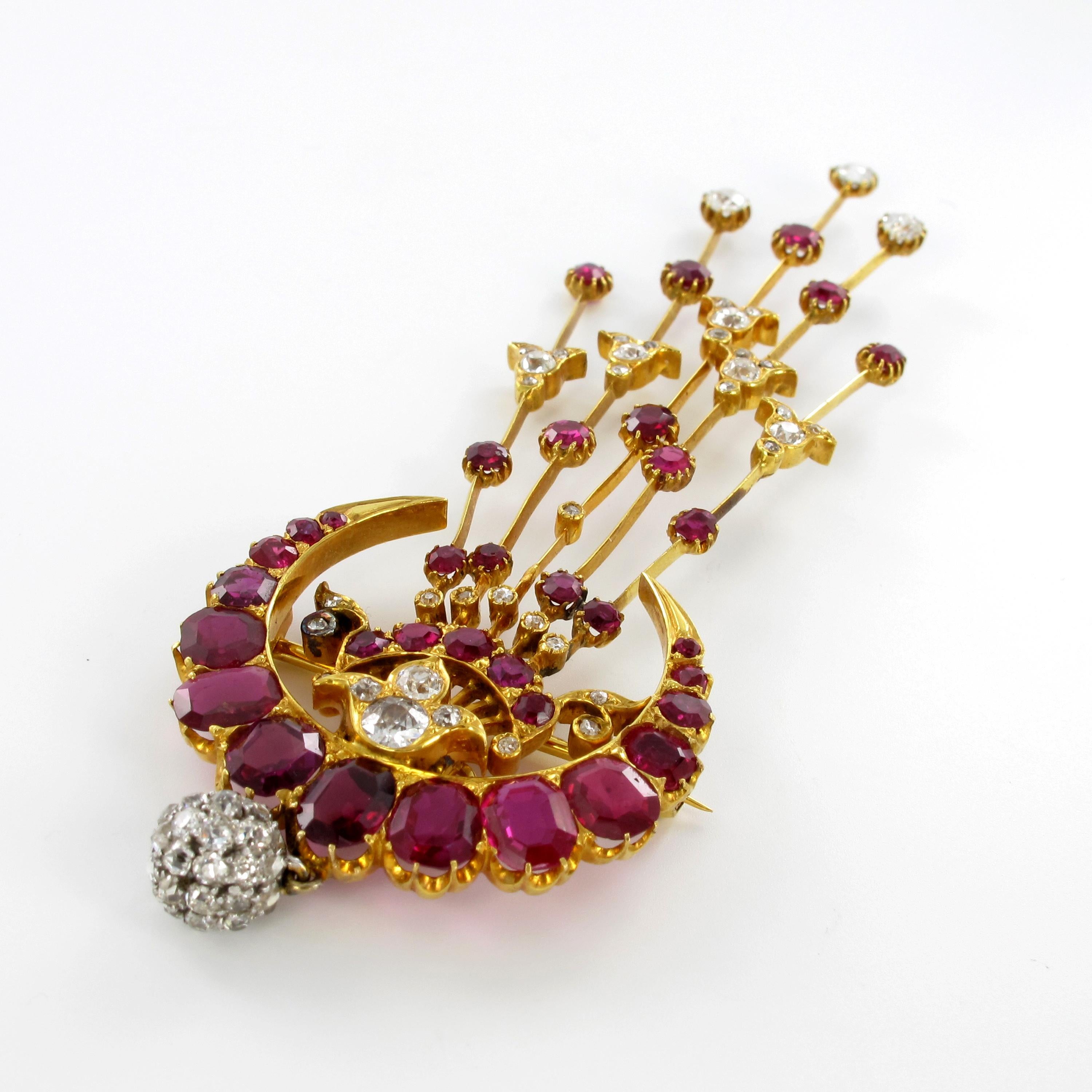 This unique and beautiful piece of jewellery is a brooch, pin and exceptional headdress all in one.
Elaborately handcrafted in 18+ carat yellow gold, it is set with 34 luminous, no enhanced, rubies from Burma, total weight approximately 8.10 carats,