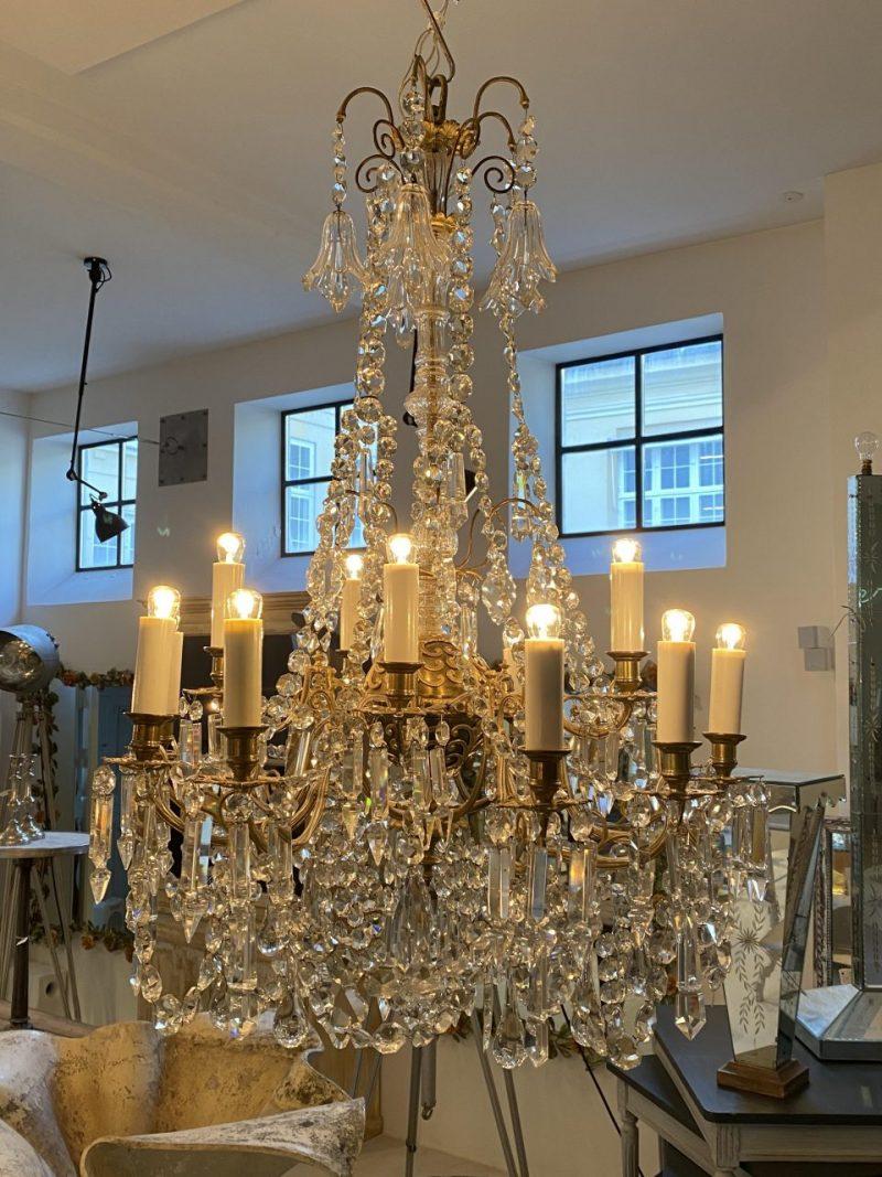 Opulent and delightful chandelier, circa 1920-1940s France. Formed in quality brass, with an elegantly ornamented brass orb in the centre.

No less than 15 light pipes staggered on two levels.

Notice the beautiful beading, countless faceted prisms,