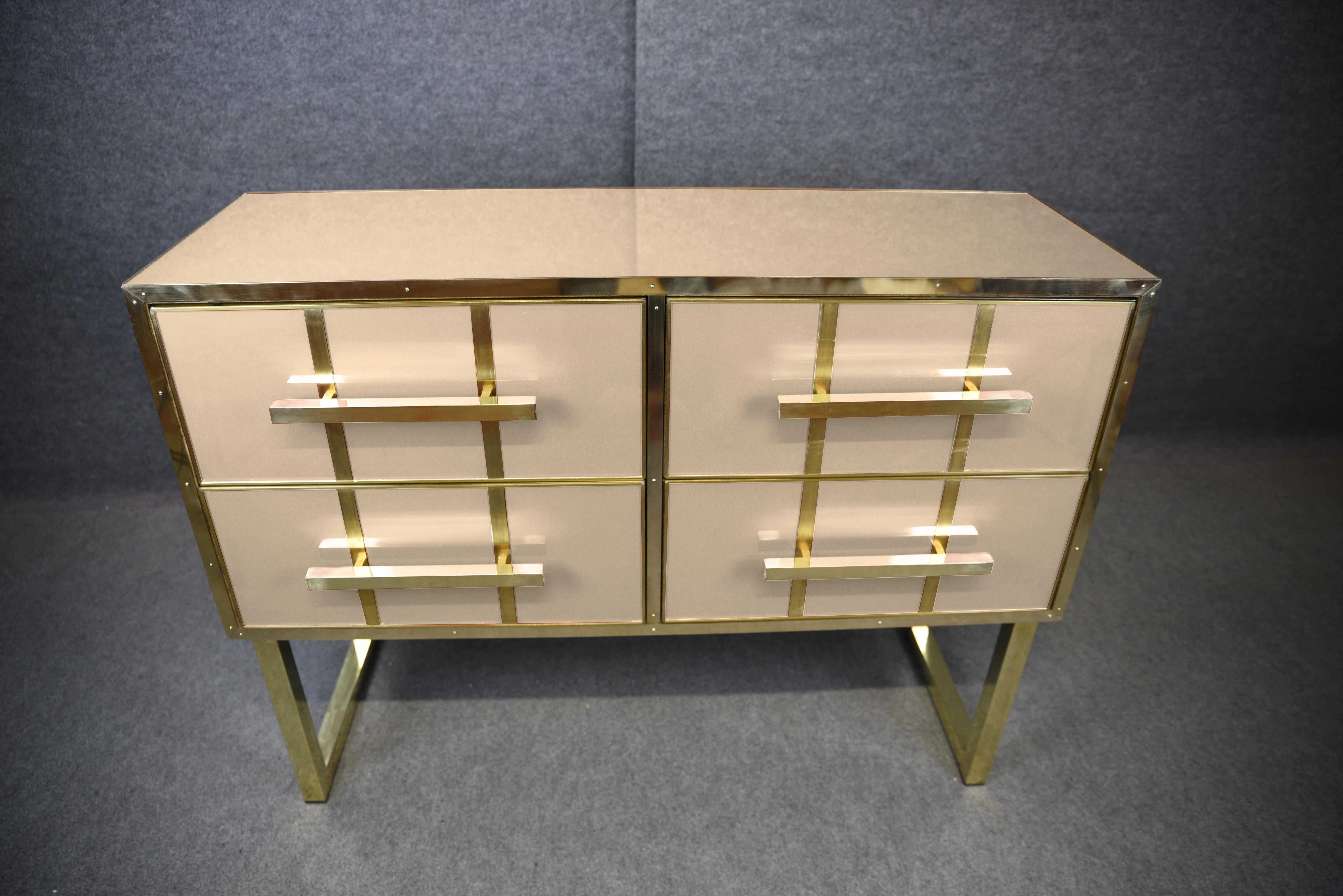 This exquisite ivory-colored chest of drawers is a masterpiece of Italian craftsmanship, fusing solid wood, Murano glass and polished brass for a truly elegant look. 

Handcrafted, it embodies the essence of Mid-Century Modern style with intricate