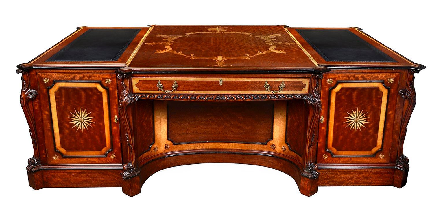 A spectacular fine quality figured Mahogany partners pedestal desk, after Thomas Chippendale. The beautiful hand carved musical instruments to the sides are taken from the Violin Bookcase in Wilton House, after the design of William Chambers for