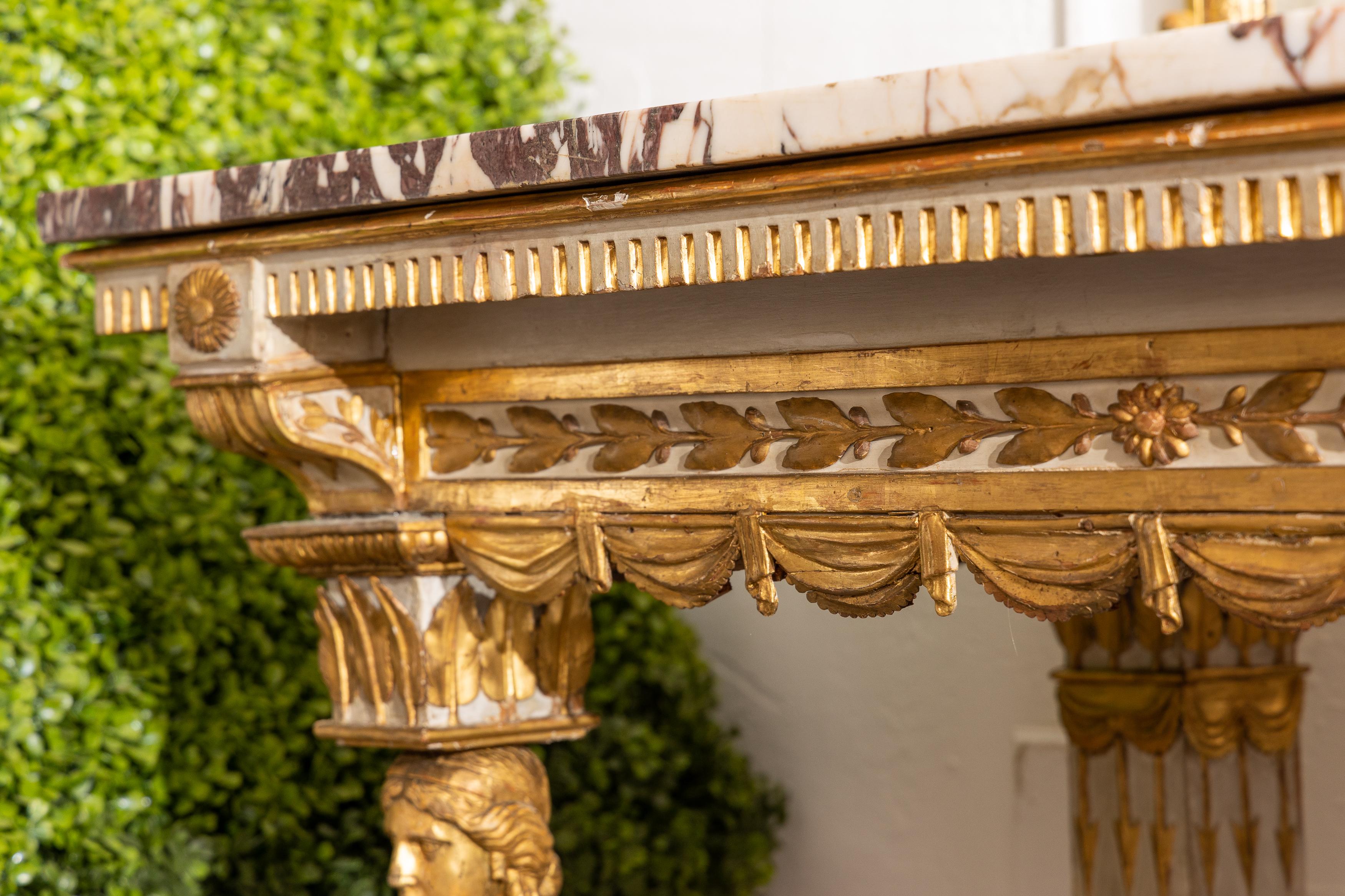 This is a lovely 19th century Italian cream-painted and parcel gilt neo-classical console, the white variegated marble top over an ornamental freeze, supported by straight reeded legs.
