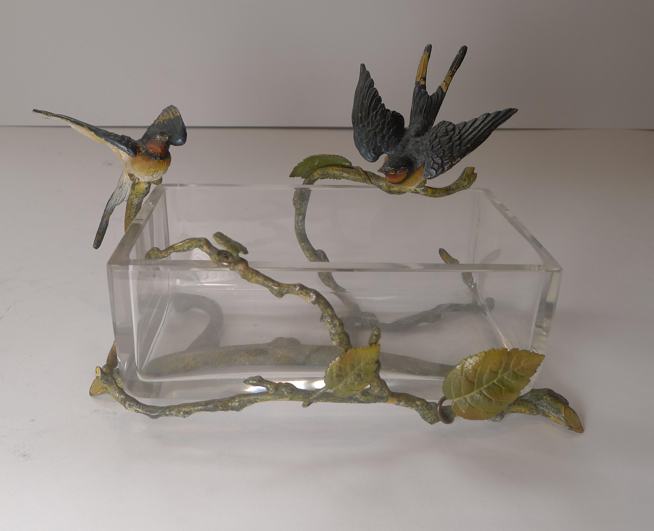 A most unusual and fantastic Vienna cold painted bronze made to wrap around this open=topped heavy crystal box.

The naturalistic frame supports two magnificent Swallows looking to be sitting around a pond or body of water; quite