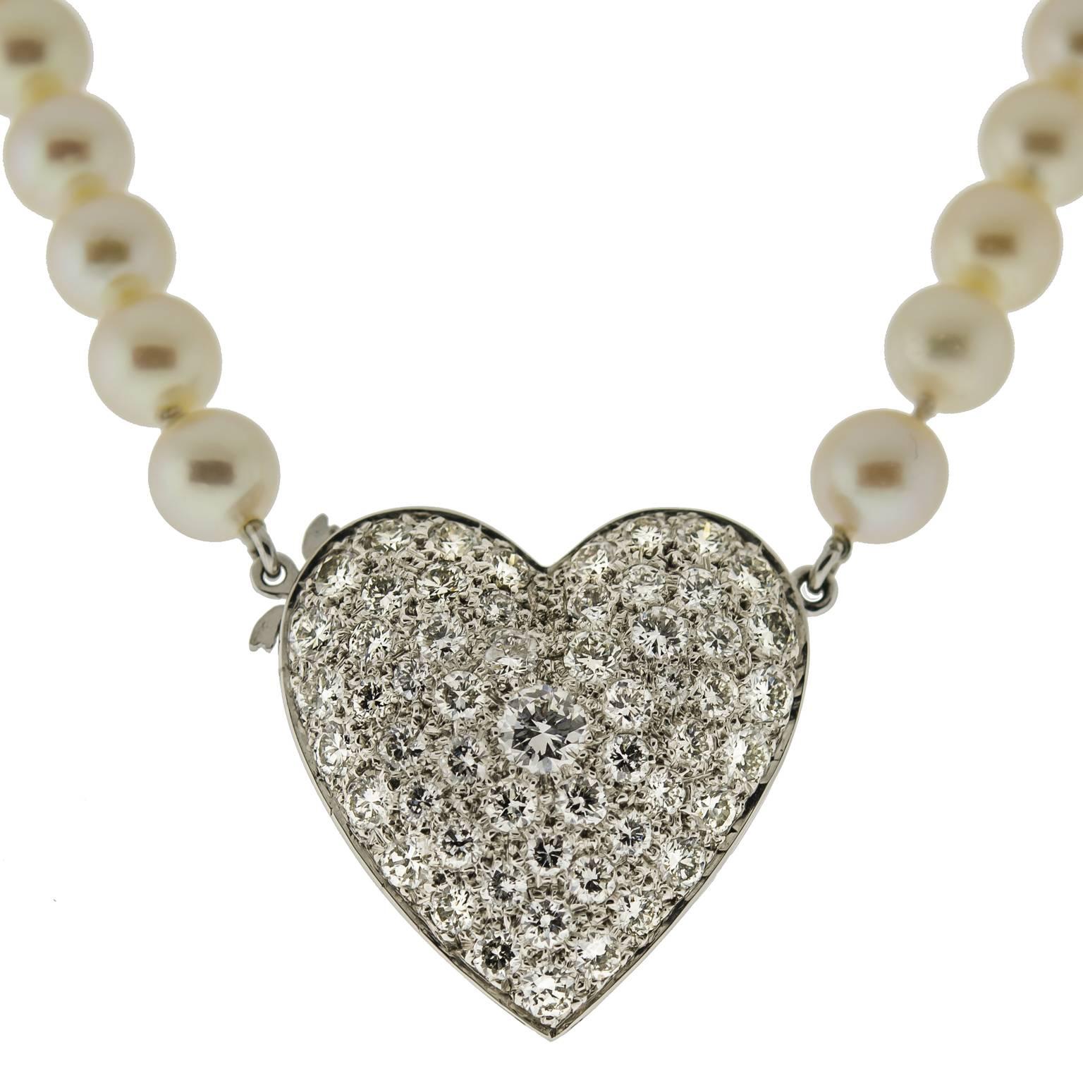 This beautiful Mid-Century cultured pearl and diamond heart necklace contains fifty-seven (57) 6mm near round cream-colored cultured pearls. One dazzling diamond and 14kt white gold heart clasp sits in the middle of this elegant necklace. The heart