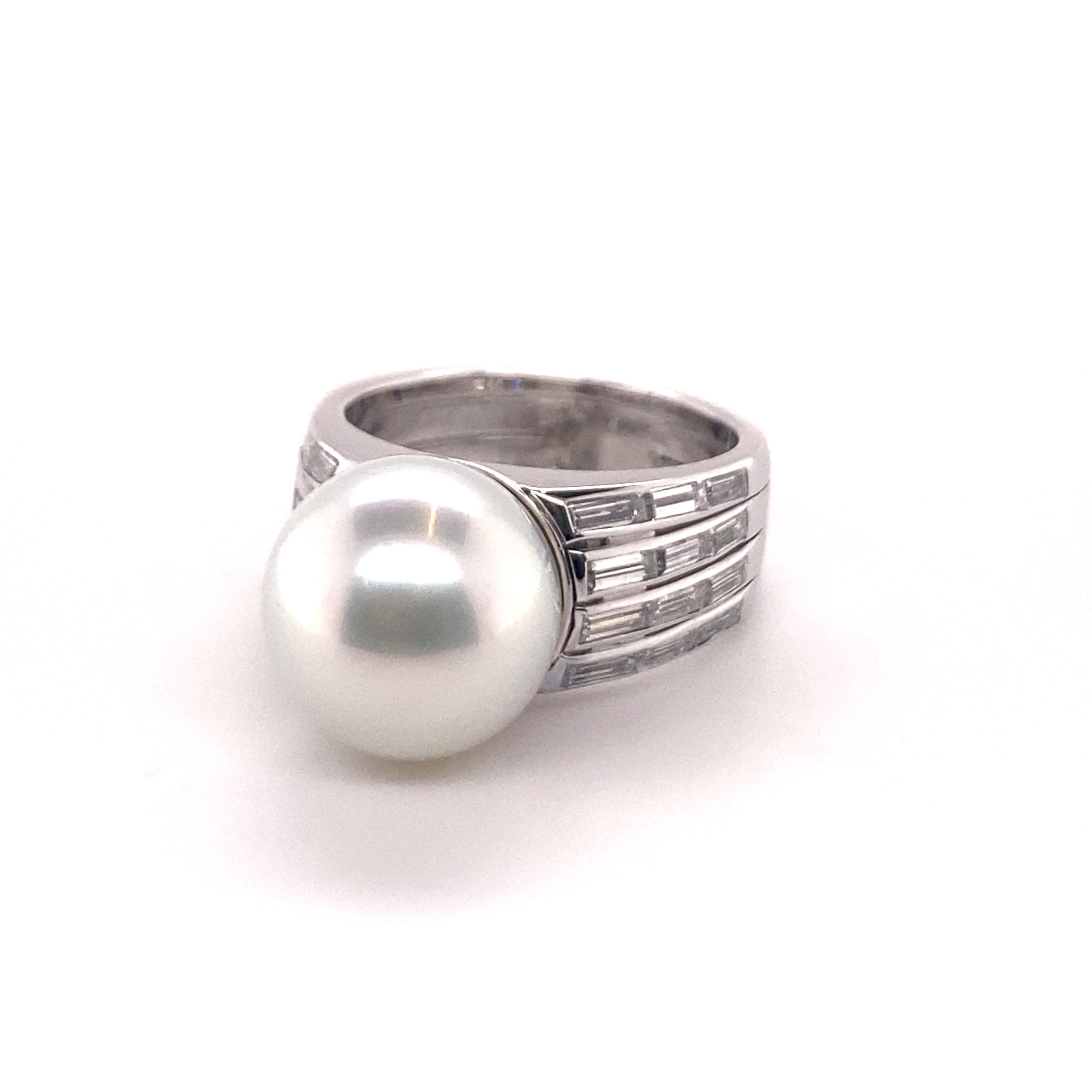Beautifully worked ring in 18 karat White Gold. Center of attraction is 12.8 mm white cultured South Sea Pearl of gem quality. The pearl is perfectly round, absolutely free of blemishes combined with a very fine luster. The pearl is possessing a
