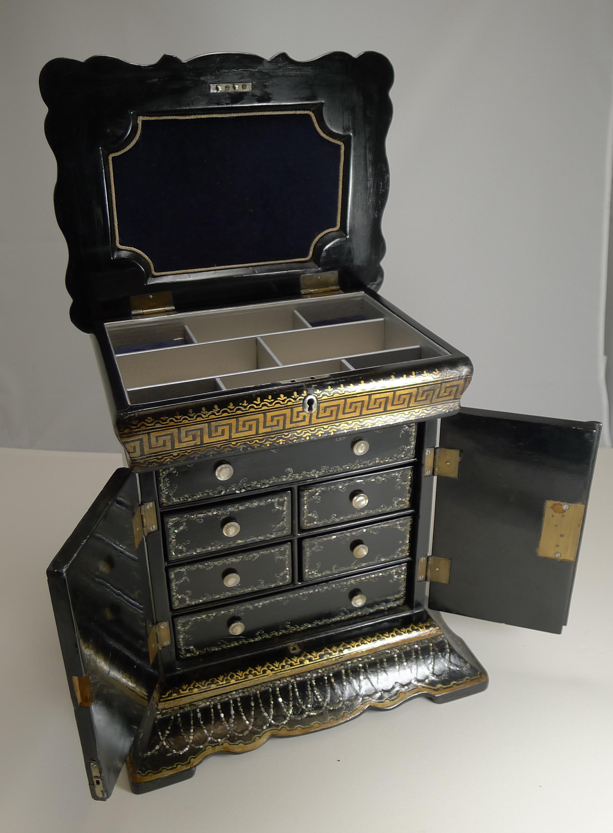 A stunning and very fine papier mâché jewellery cabinet dating to circa 1860, mid-Victorian in era.

The box is inlaid all over with tiny tiles of Mother of Pearl including the interior on the front of the drawers. The front has two raised panels