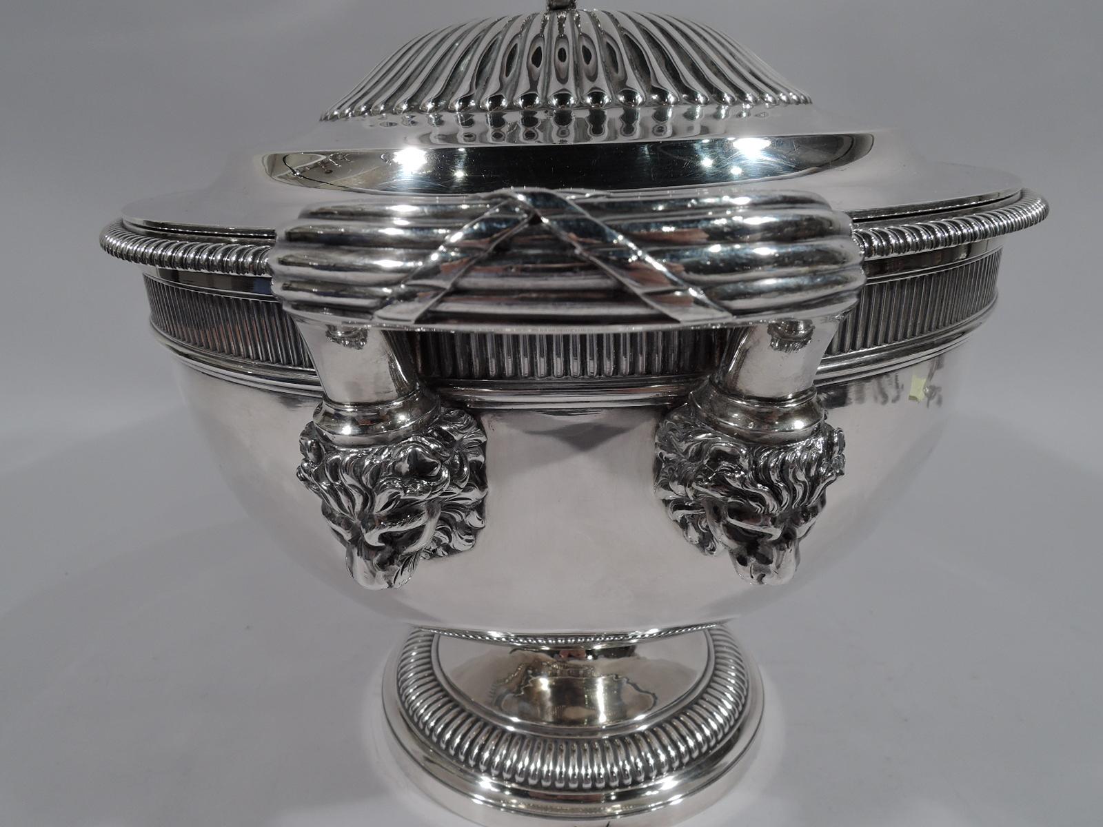 George III sterling silver soup tureen. Made by Paul Storr in London in 1804. Round bowl on raised foot. Reeded bracket side handles with cast lion’s head mounts. Double-domed cover with reeded and leaf-capped ring finial. Ornament: Bead-and-reel,