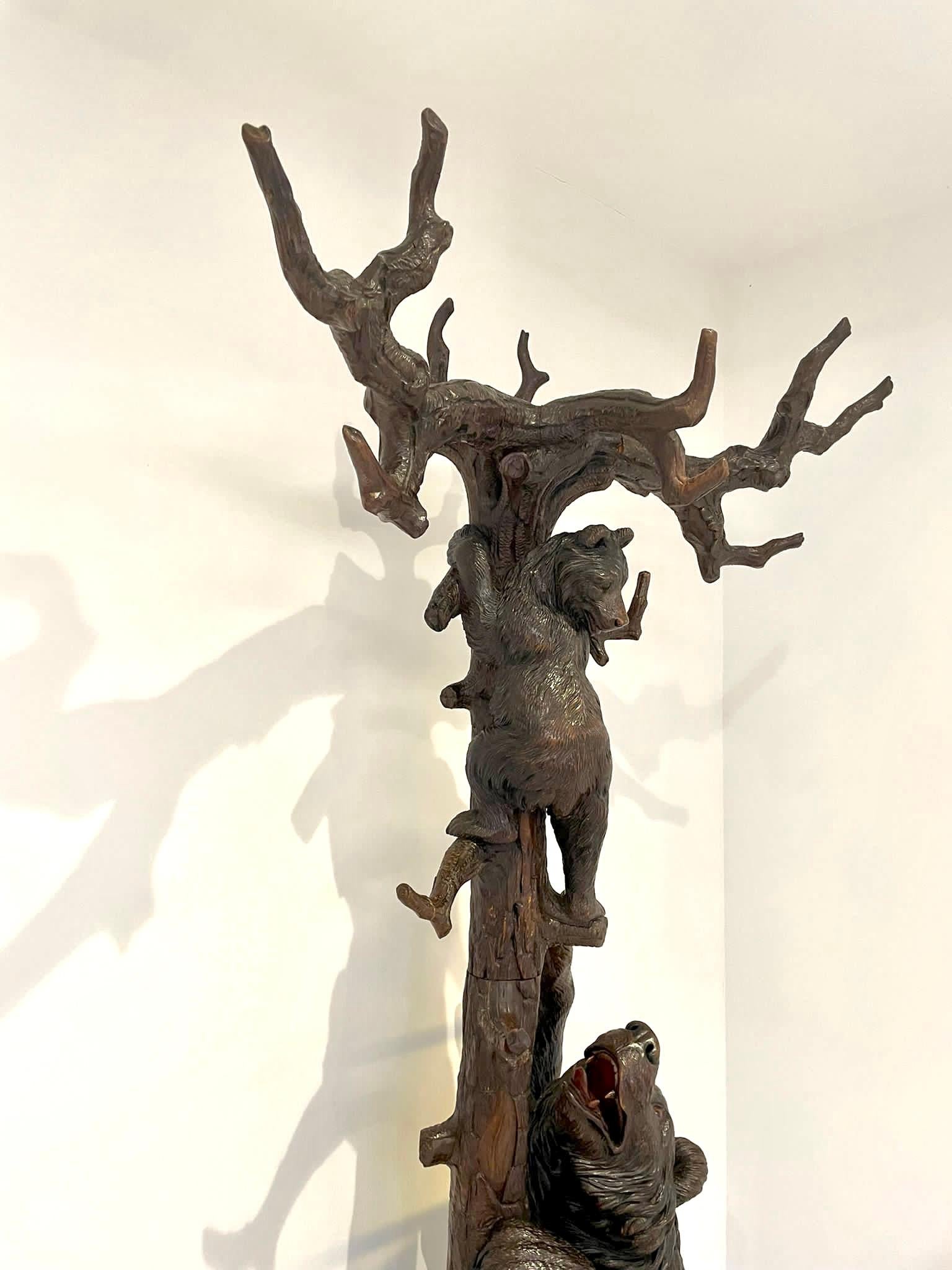 Ce magnifique stand d'exposition antique pour arbre à ours de la Forêt-Noire présente deux ours sculptés de qualité spectaculaire : la mère ours encourage son petit à grimper dans l'arbre, les branches formant des portemanteaux et la mère ours se