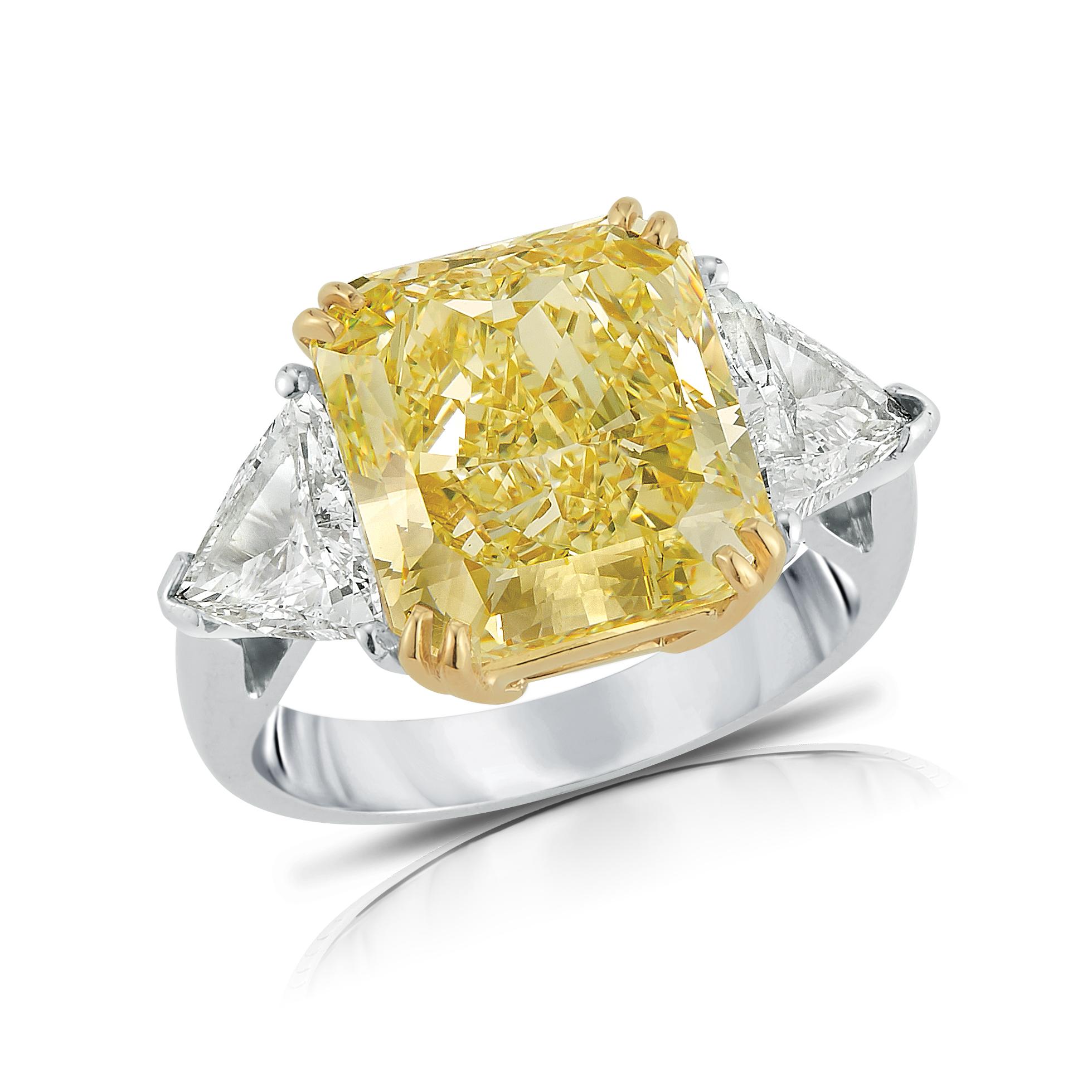 Magnificent Platinum & 18K Yellow Gold Engagement Ring, set in the center with Fancy Yellow 7.49C. VVS1 Cushion cut Diamond, GIA certified, flanked by two triangles Diamonds weight 1.38C. F color VS1 clarity. Total weight of the Diamonds is 8.87C.