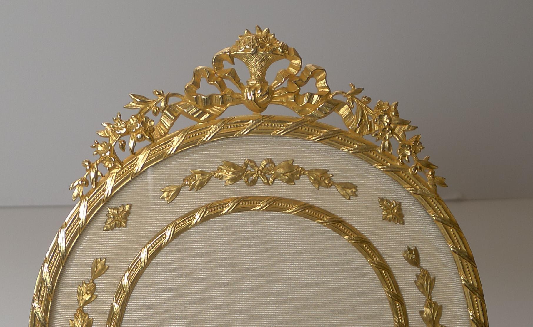 A magnificent and grand photograph frame; if you are looking for a statement piece, this may very well be it.

Made from Ormolu or gilded bronze, it has been meticulously restored to it's former glory with a bright patina, clean silk taffeta and a