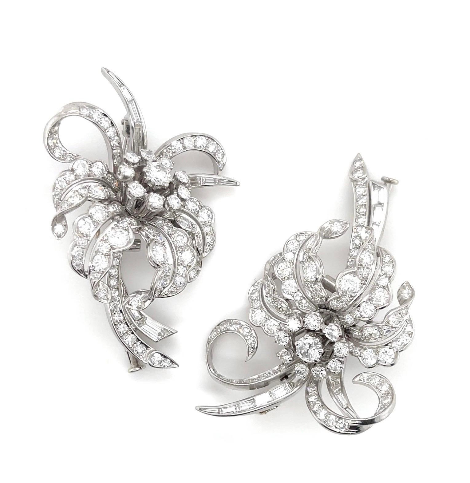 The casted and assembled floral design dress clips with Platinum detachable frame, circa 1950's, measure 66 x 52 mm., weighs 45.9 grams and contain:
Two (2) round brilliant cut Diamonds, total weight (TW) approx. 0.80 ct., F-G/VS qualities, good