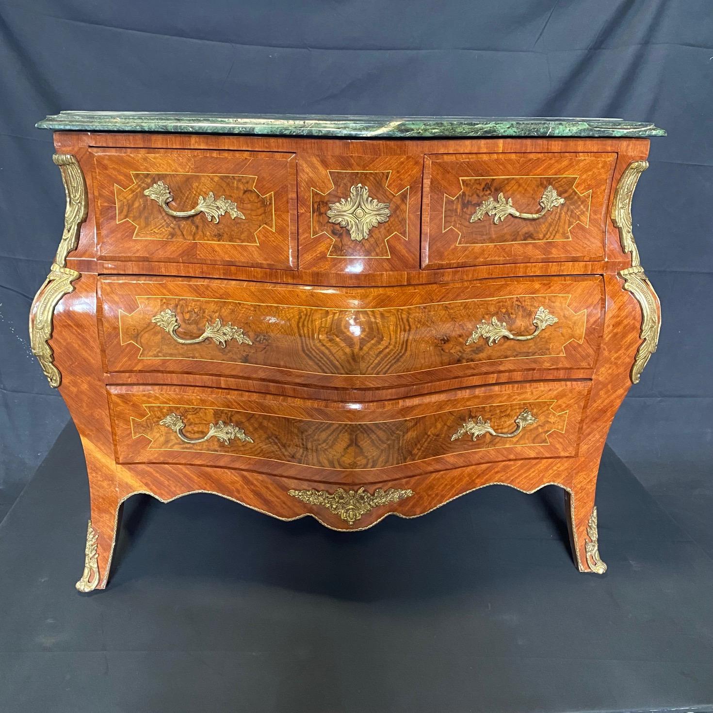 Very high quality French serpentine bombe commode or chest of drawers in Louis XV style with original marble top having really beautiful walnut inlay on drawers and sides and rococo ormolu handles and on the cabriole legs to the sabot feet. 

