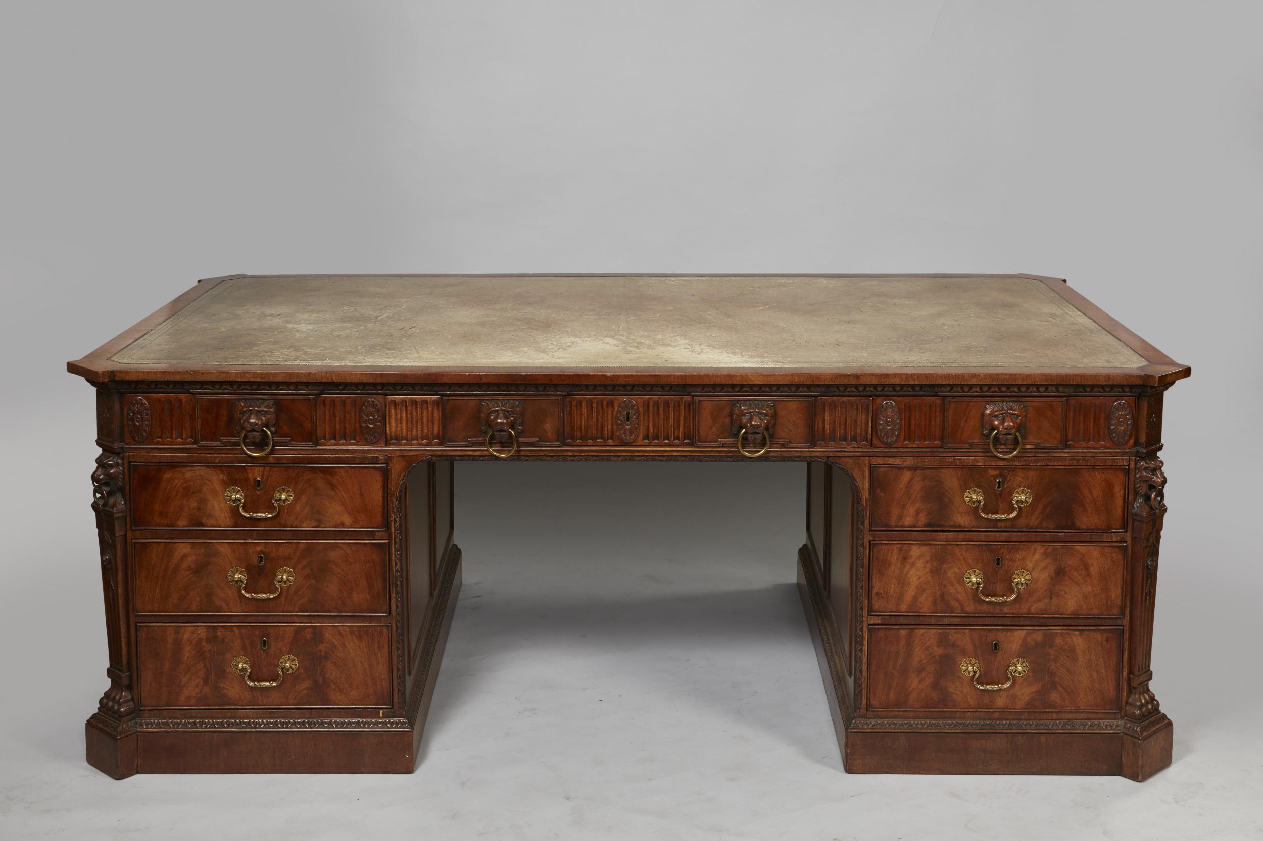 Important Late George IV Carved Mahogany Partner's Pedestal Desk

The top with canted corners and fitted with a grey gilt tooled leather writing surface above three frieze drawers with ring nosed carved lion mask pulls and fluted frieze with