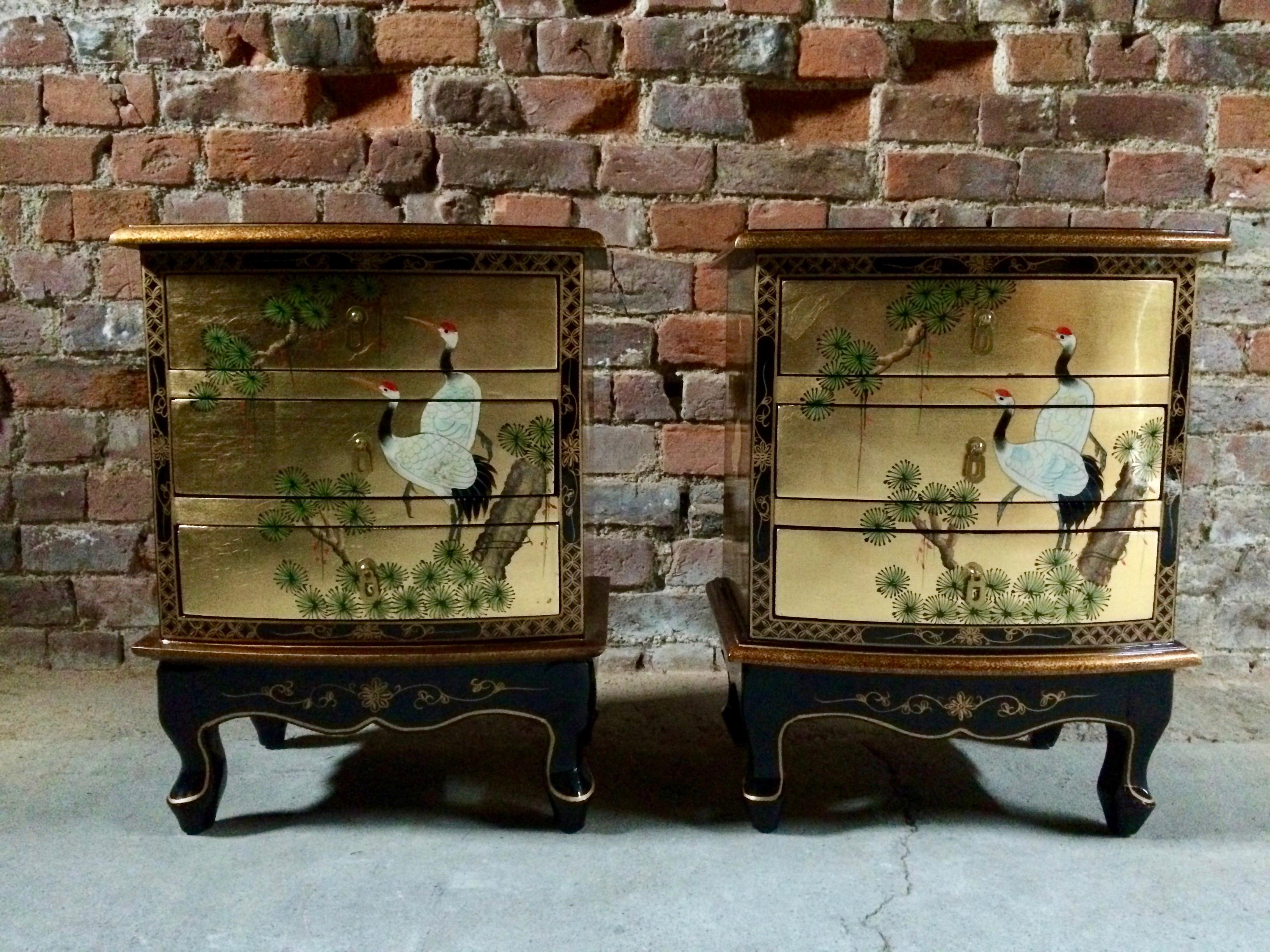 A stunning pair of late 20th century Japanese nightstands bedside tables and matching trunk, the lacquered finish with images of exotic cranes and lotus trees, finished in golds and reds, the overhanging rectangular top over three green felt lined