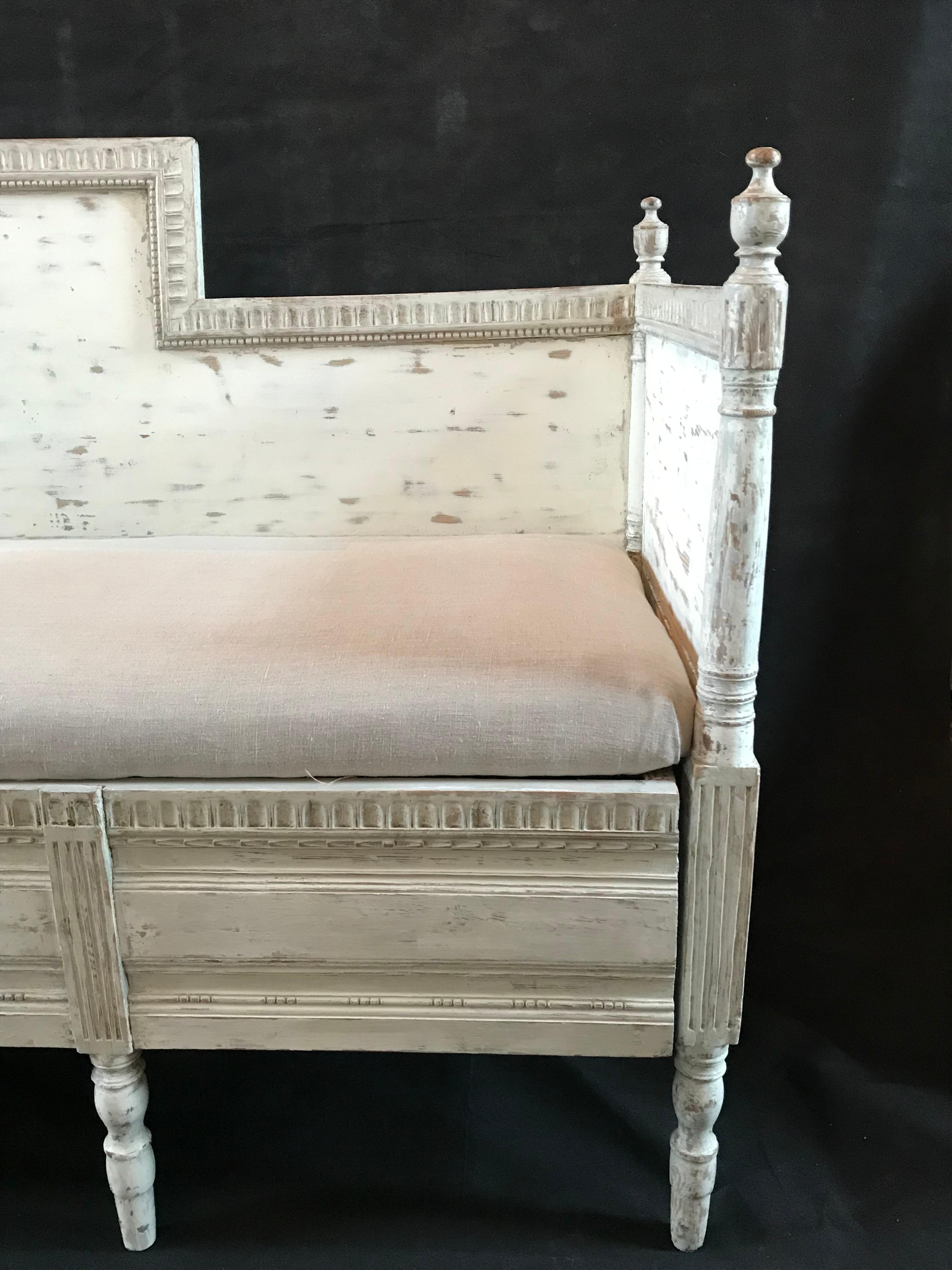 A Swedish Gustavian painted settee or sofa in a gorgeous antiqued grayish white, with classic simple carved wood frame, pretty finials and newly upholstered cushion seat.
#4721
H to seat 19”.