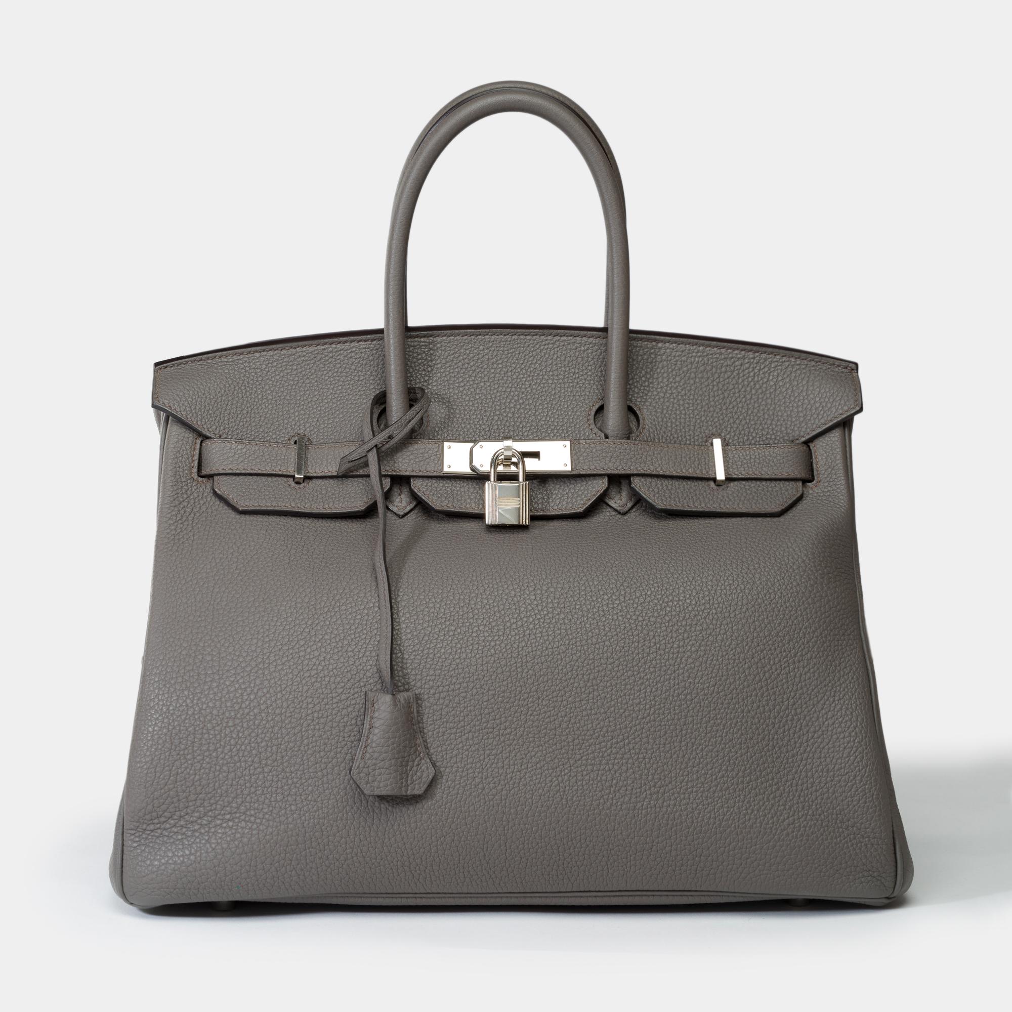Magnificent​ ​Hermes​ ​Birkin​ ​35​ ​in​ ​Togo​ ​etain​ ​leather​ ​,​ ​palladium​ ​silver​ ​metal​ ​trim,​ ​double​ ​handle​ ​in​ ​gray​ ​leather​ ​for​ ​a​ ​hand​ ​carry

Flap​ ​closure
Black​ ​leather​ ​lining,​ ​a​ ​zippered​ ​pocket,​ ​a​