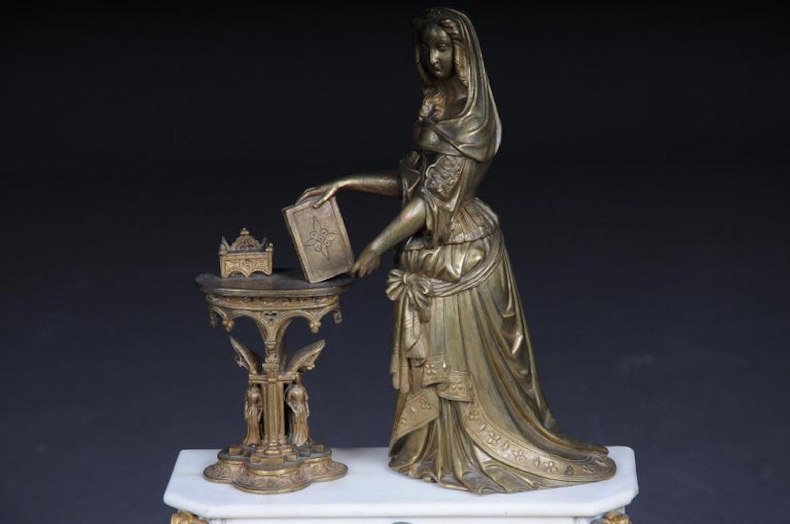 Magnifico orologio o orologio da caminetto dello storicismo del 1890 circa

Sul piedistallo c'è la figura di una nobildonna con un diadema e un libro su un tavolo gotico, con sopra degli utensili per scrivere. Quadrante smaltato con fregio ad arco.